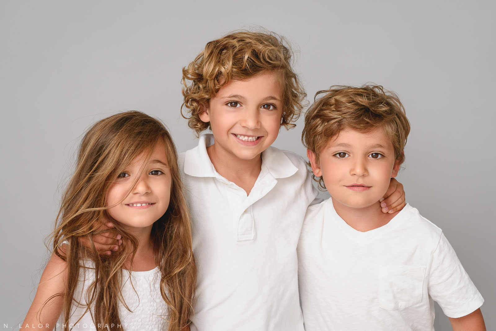 Three kids together. Family photo session by N. Lalor Photography in Greenwich, CT.
