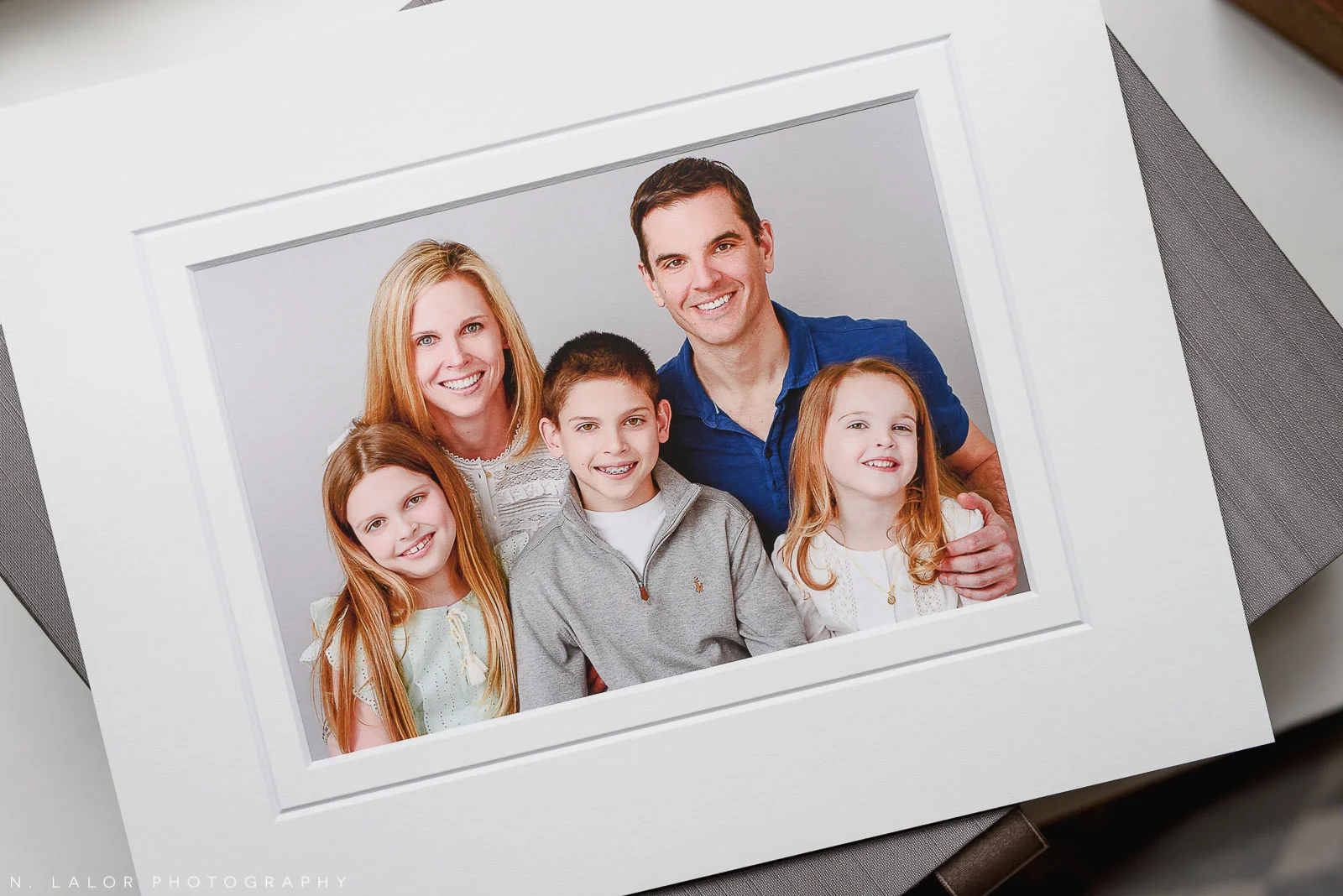 Image of a archival print, showing photograph of a family wearing coordinated outfits as part of their Studio photo session with N. Lalor Photography.