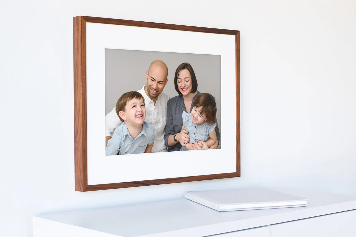 Image of a large printed frame showing a happy laughing family. Studio portrait by N. Lalor Photography in Greenwich Connecticut.