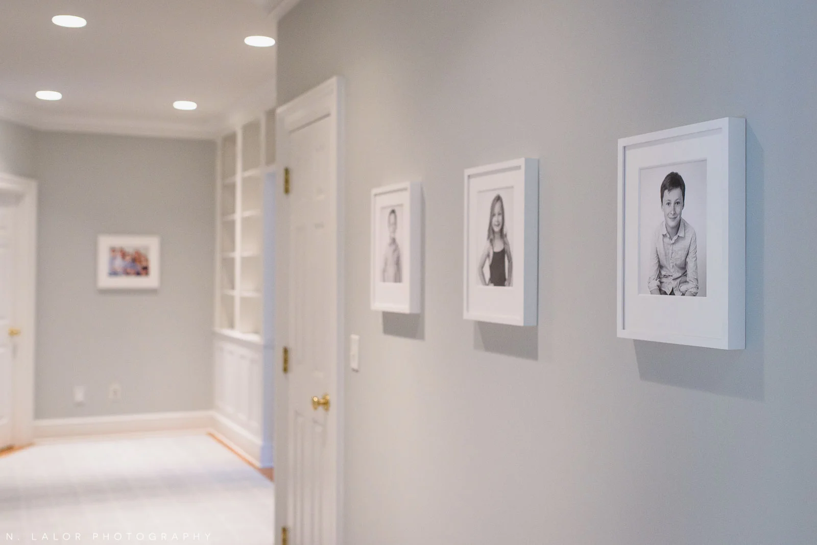 Image of a wall of framed family photographs. Photos by N. Lalor Photography, Studio located in Greenwich Connecticut.