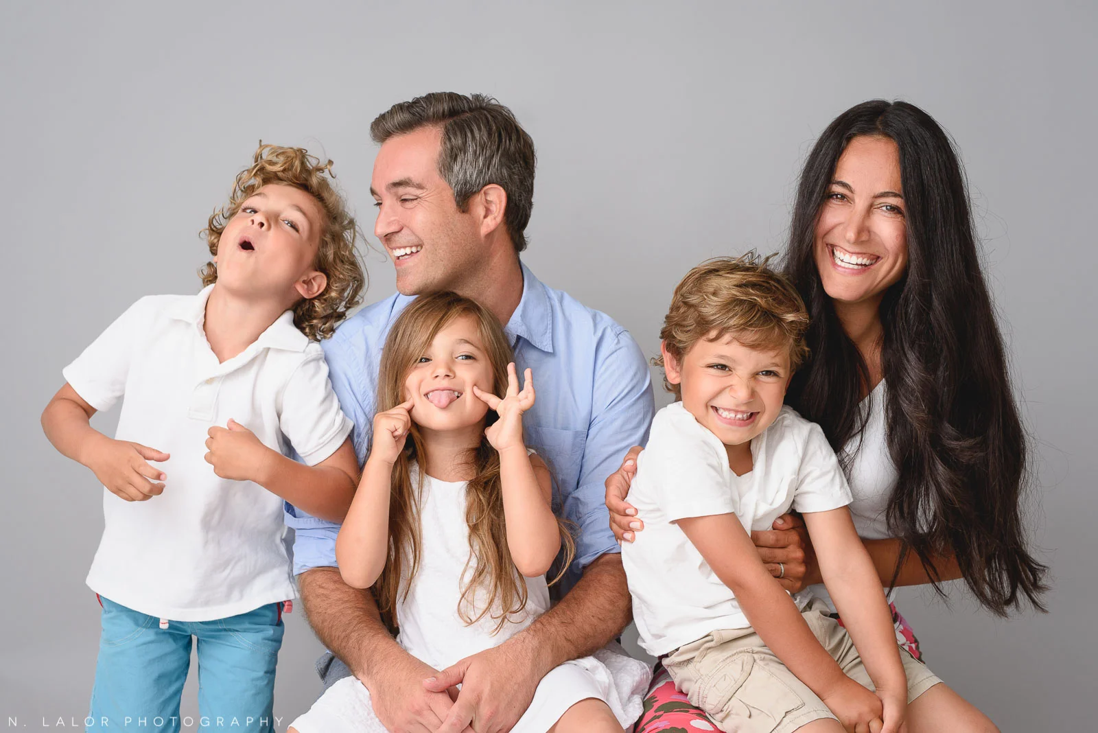 Image of a happy silly family with three kids. Studio portrait by N. Lalor Photography in Greenwich Connecticut.
