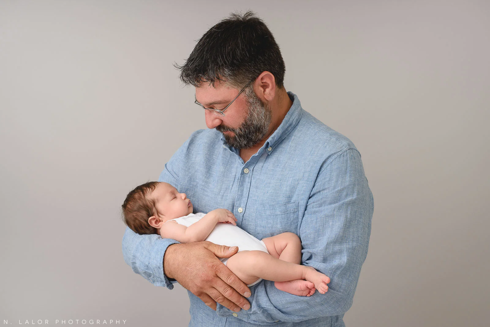 Image of a father and his new baby girl. Portrait by N. Lalor Photography, Studio located in Greenwich Connecticut.