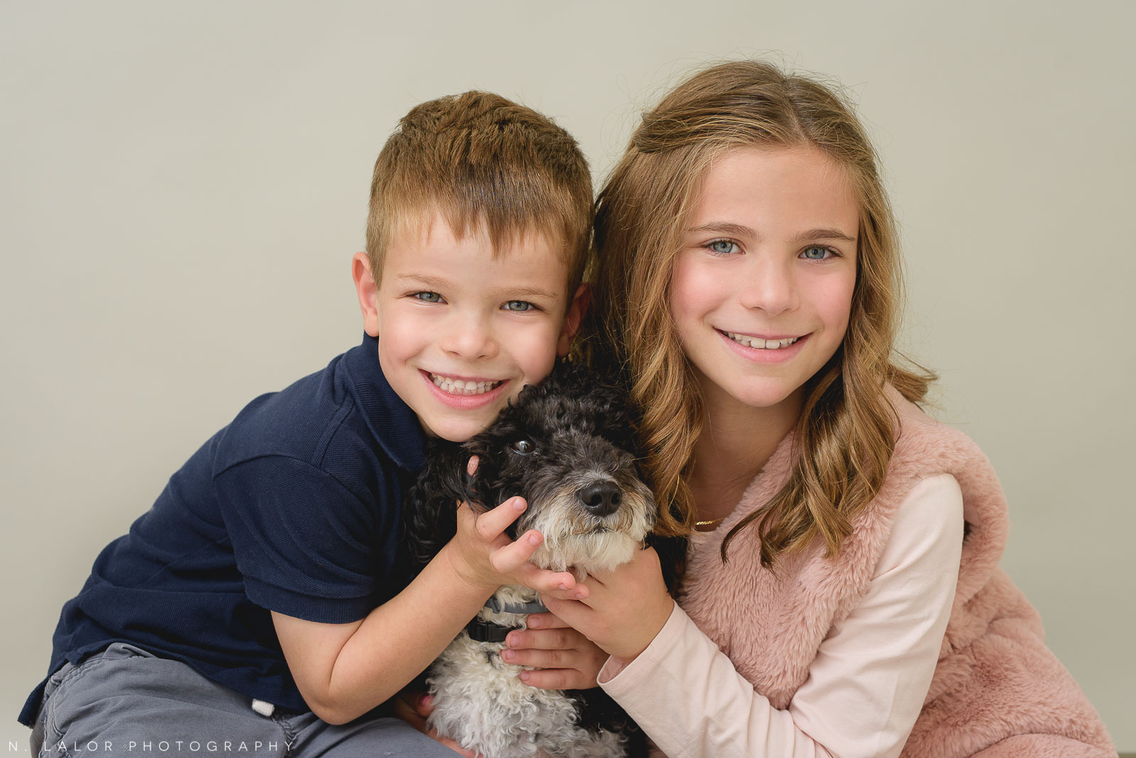 Image of two children with their dog. Portrait by N. Lalor Photography, Studio located in Greenwich Connecticut.