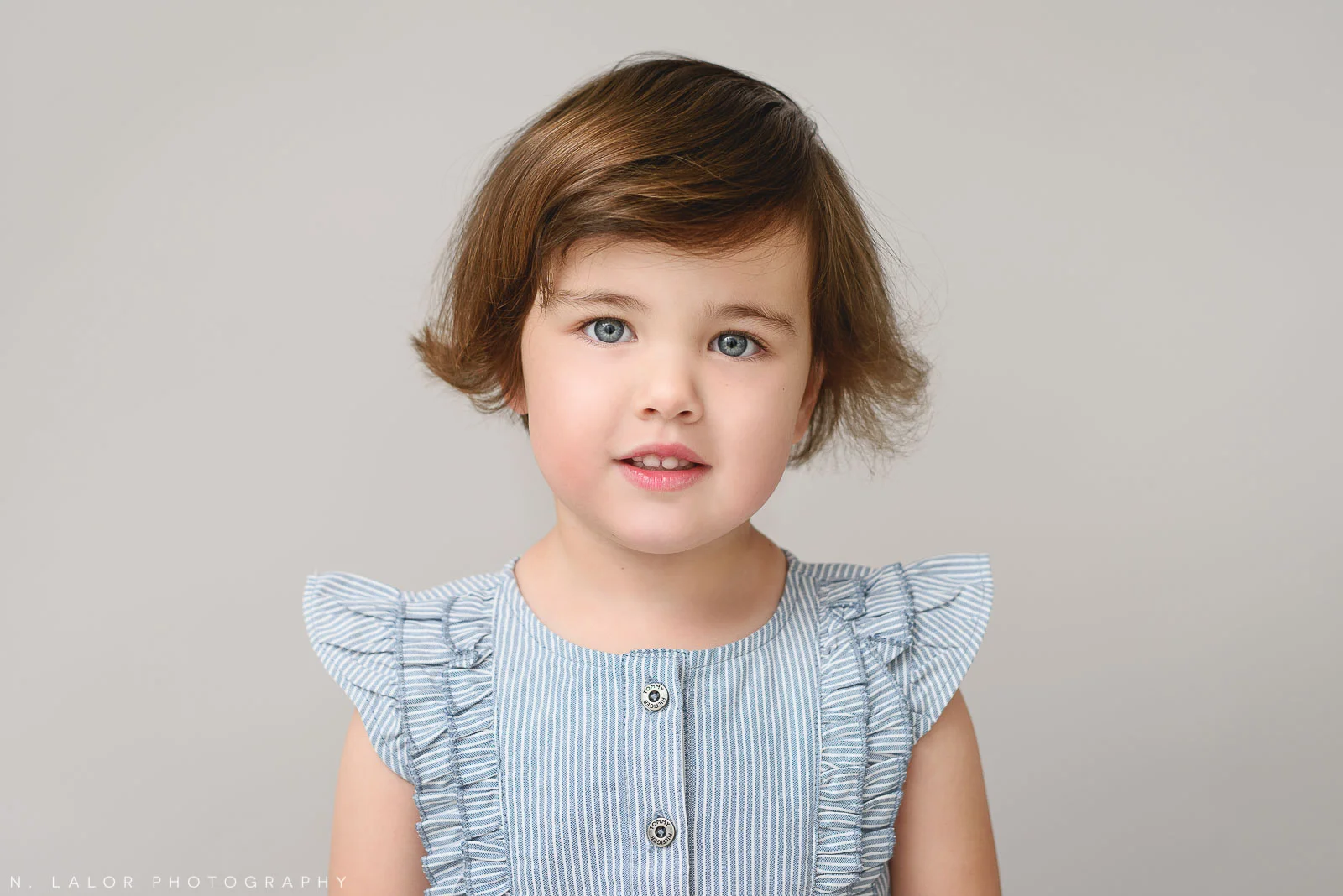 Image of a young girl looking at the camera. Portrait by N. Lalor Photography in Greenwich, Connecticut.