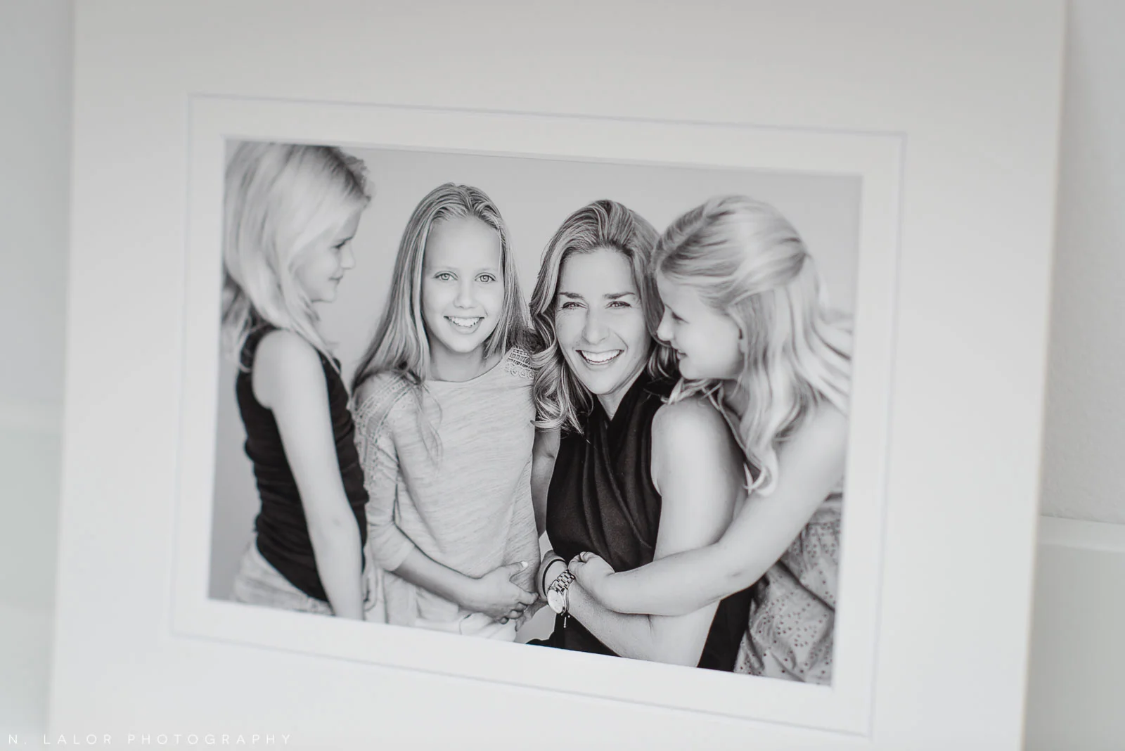 Image of a mom with her daughters, laughing. Studio family portrait by N. Lalor Photography in Greenwich, Connecticut.
