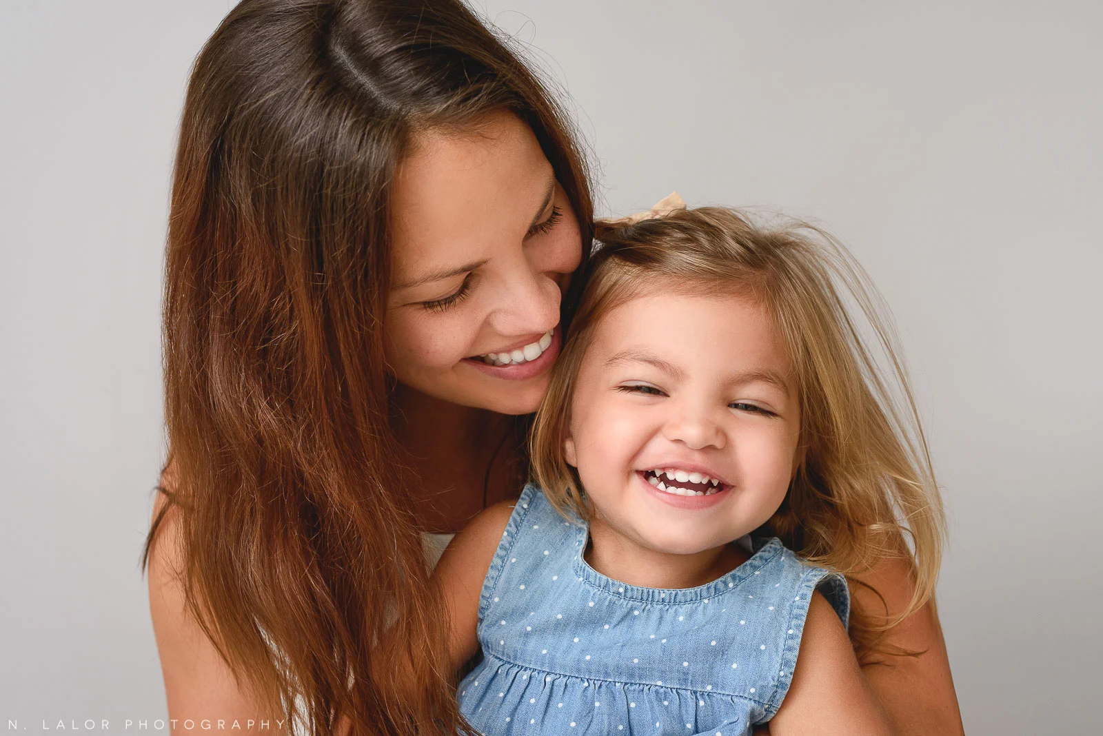Image of a Mom laughing with her toddler girl. Studio family portrait by N. Lalor Photography in Greenwich Connecticut.