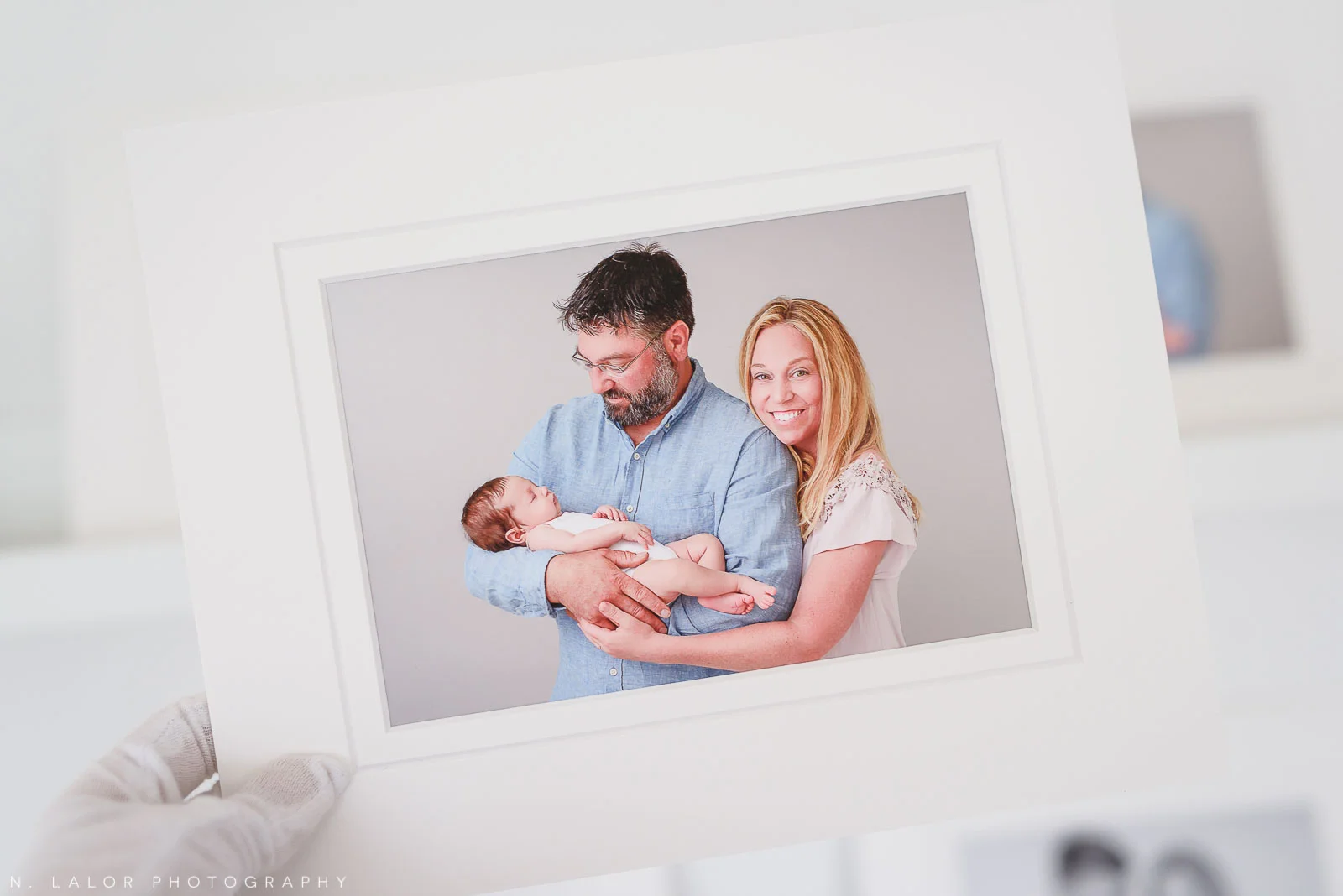 Image of a museum-quality print showing a Mom and Dad with their new baby girl. Studio portrait by N. Lalor Photography in Greenwich, Connecticut.