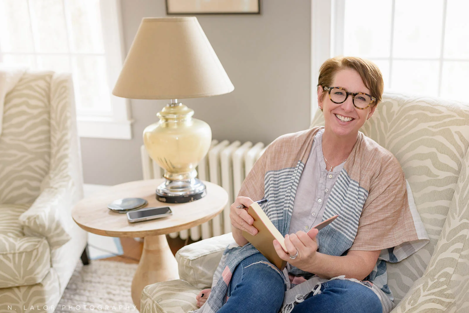 Image of a woman social media expert in her home, writing in a notebook. Lifestyle personal branding portrait by N. Lalor Photography. Serving Fairfield County, Connecticut.