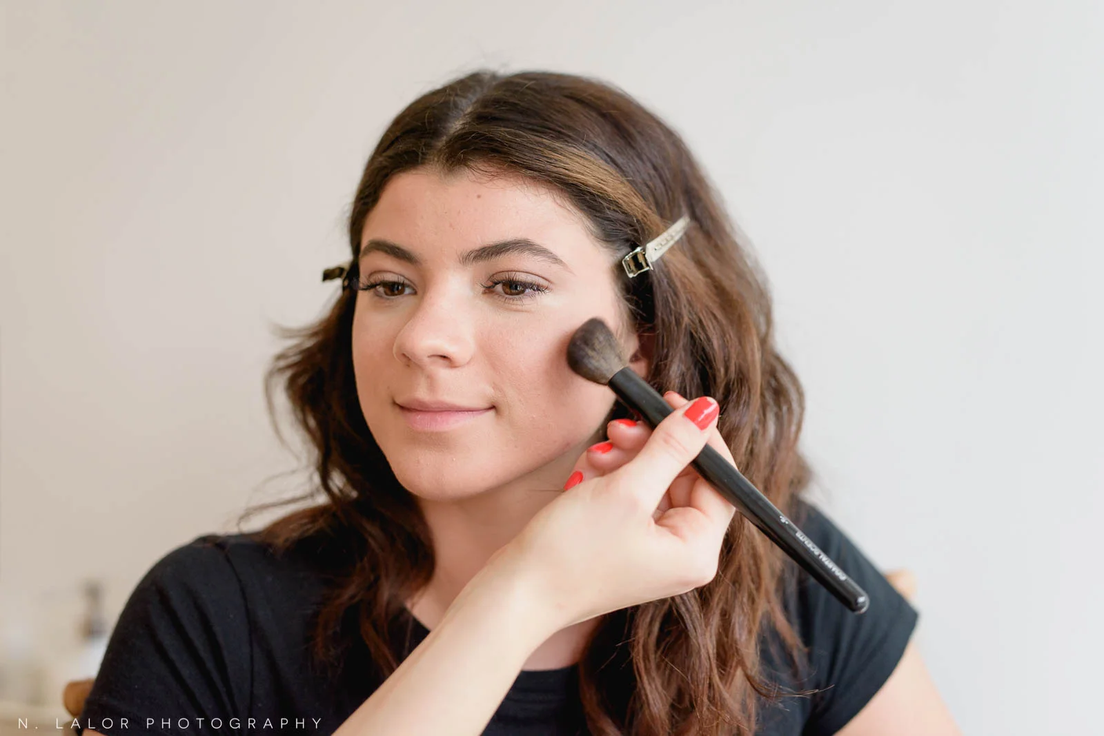Applying blush on the apples of cheeks. Photo by N. Lalor Photography, makeup tips by Haus of Pretty of Westport CT.