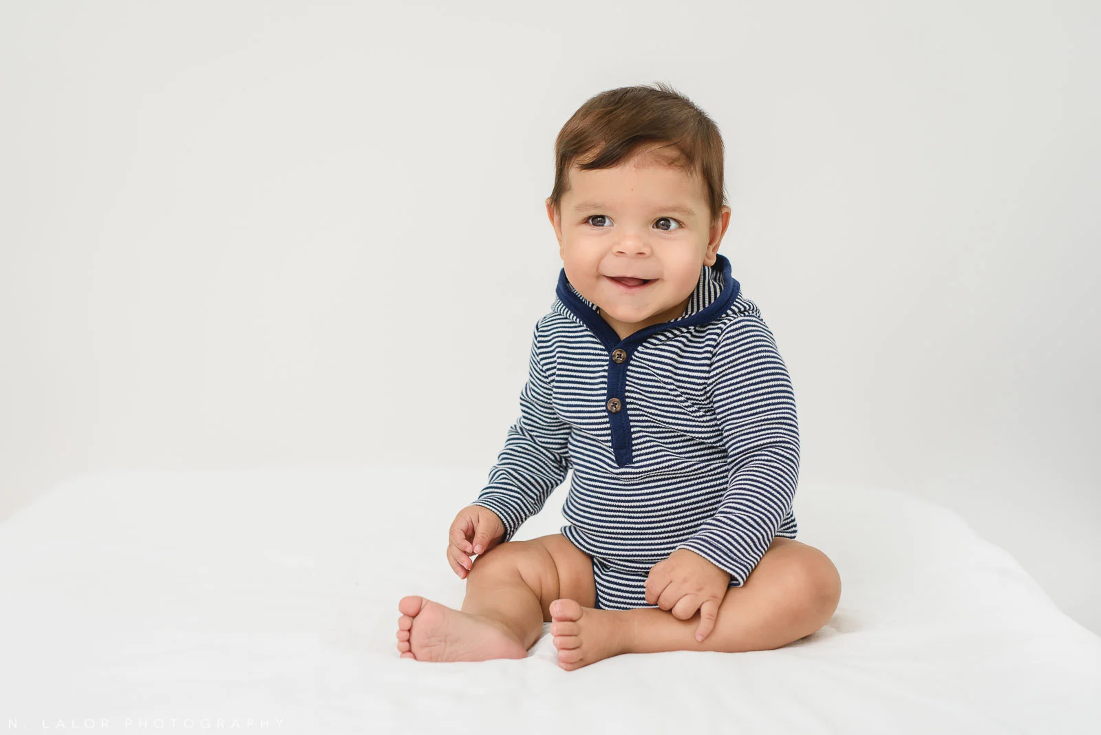 Image of smiling baby sitting up during Milestone Sessions photo shoot. Milestone Sessions by N. Lalor Photography. Studio in Greenwich, Connecticut.