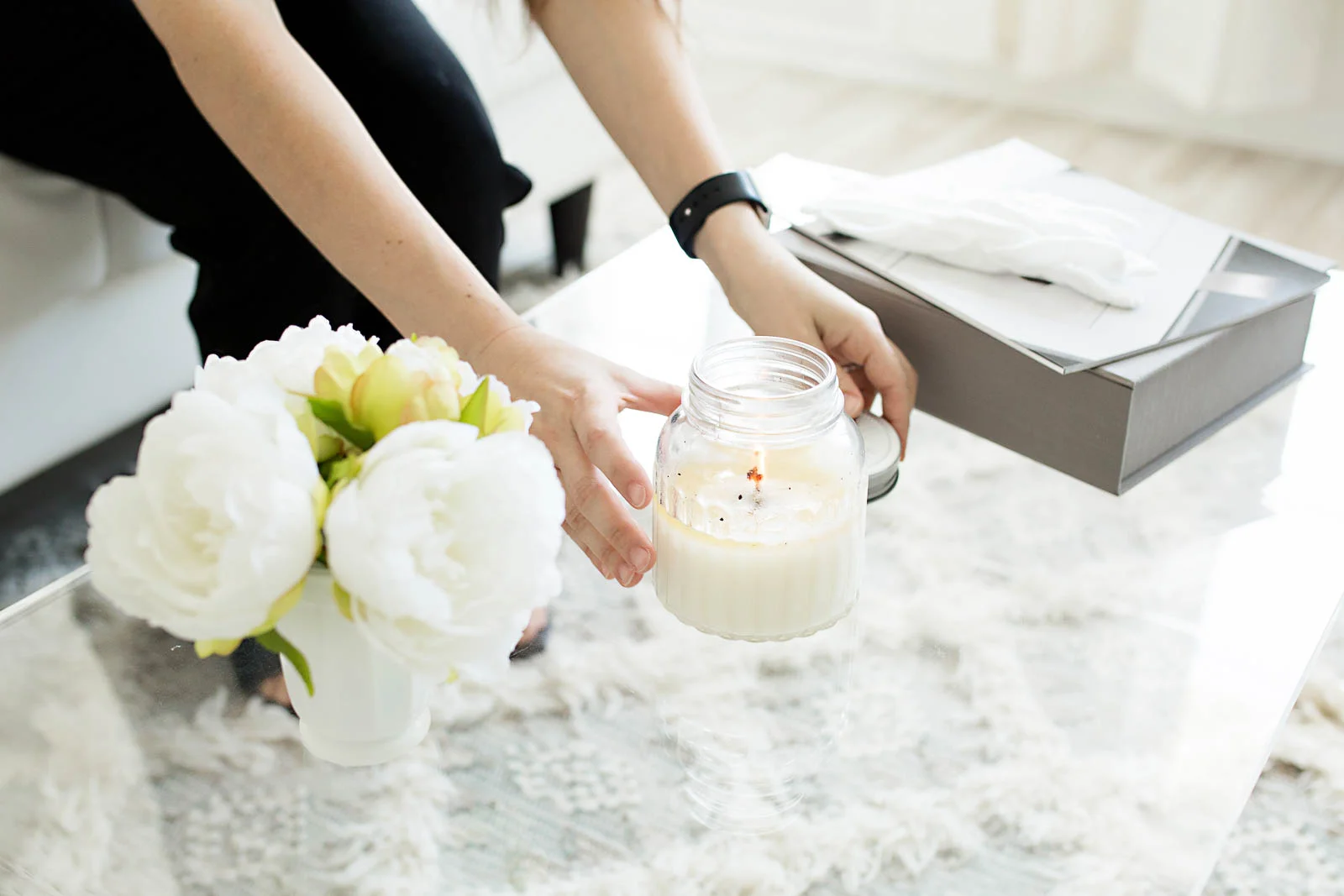 Image of Nataliya Lalor preparing her studio for a family by lighting a candle and setting out flowers. Photo taken in N. Lalor Photography in Greenwich, Connecticut.