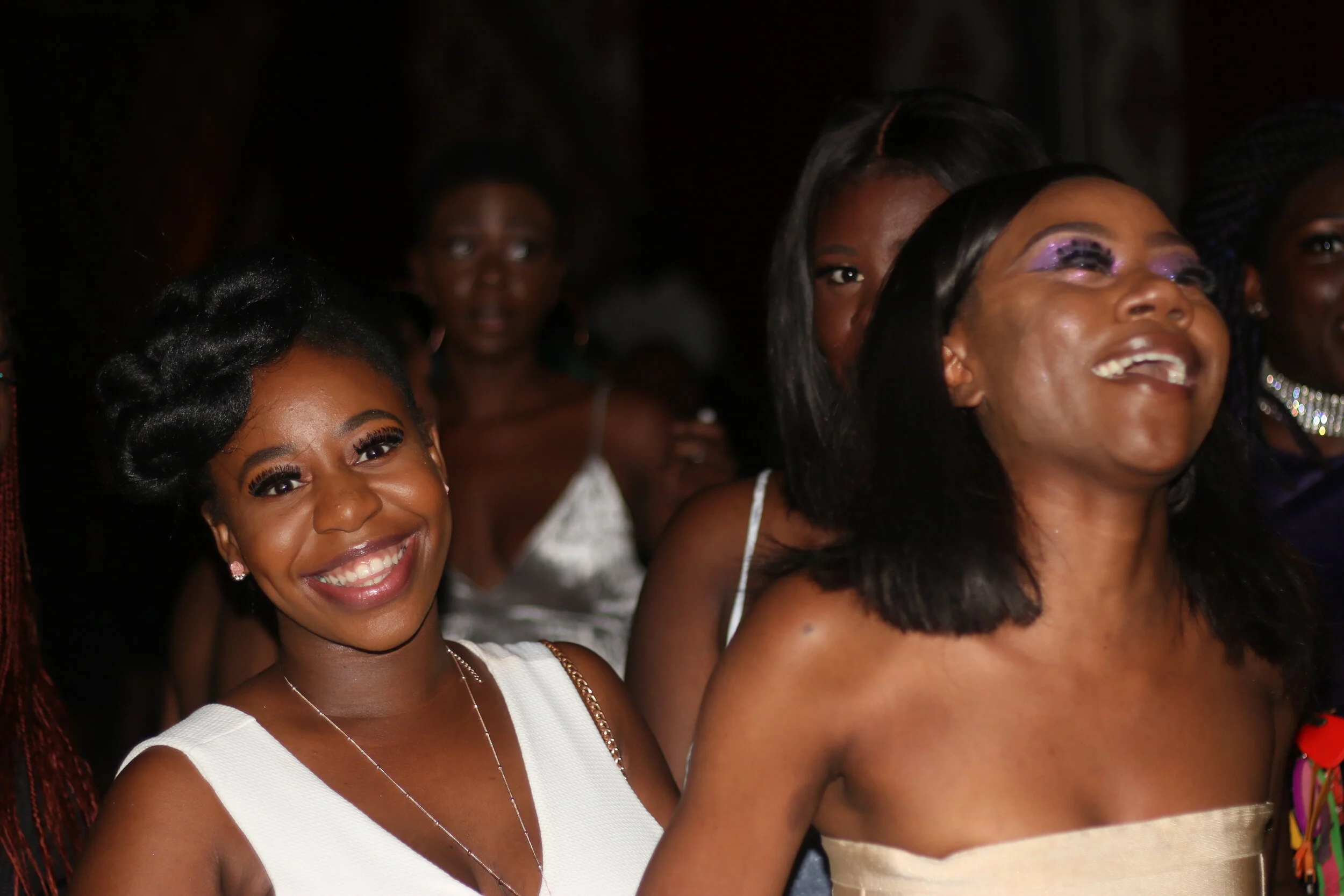 A group of women at a celebration, smiling and dressed in elegant attire at a Dott Daley event.