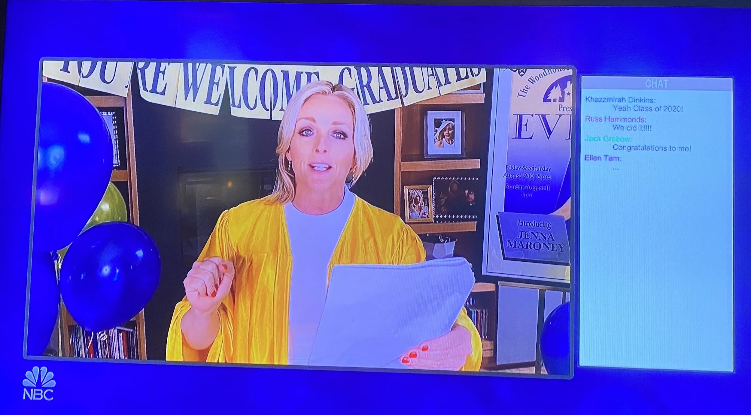 TV screen displaying a woman in a yellow graduation gown reading a paper, with a party background including blue balloons, a banner that reads 'WELCOME GRADUATES,' and a poster for an event featuring Jenna Maroney, with a chat box on the right showin