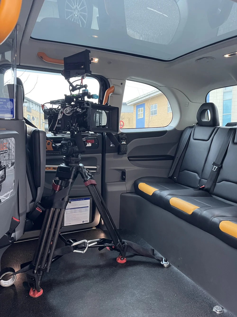 Internal studio setup of a professional camera rig with lighting and audio equipment inside a London black cab for dialogue filming