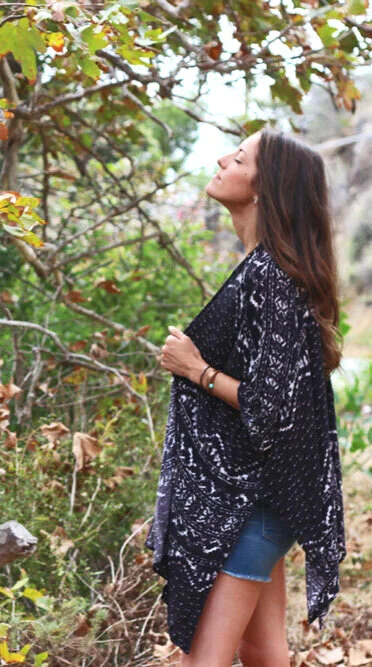 Beth standing in the trees, breathing in with eyes closed.