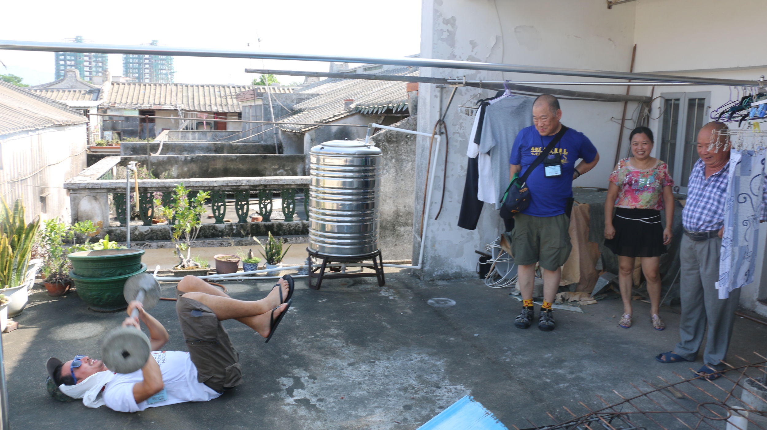 Gino demonstrates his strength on the roof of my third granduncle's home with Steve looking on.