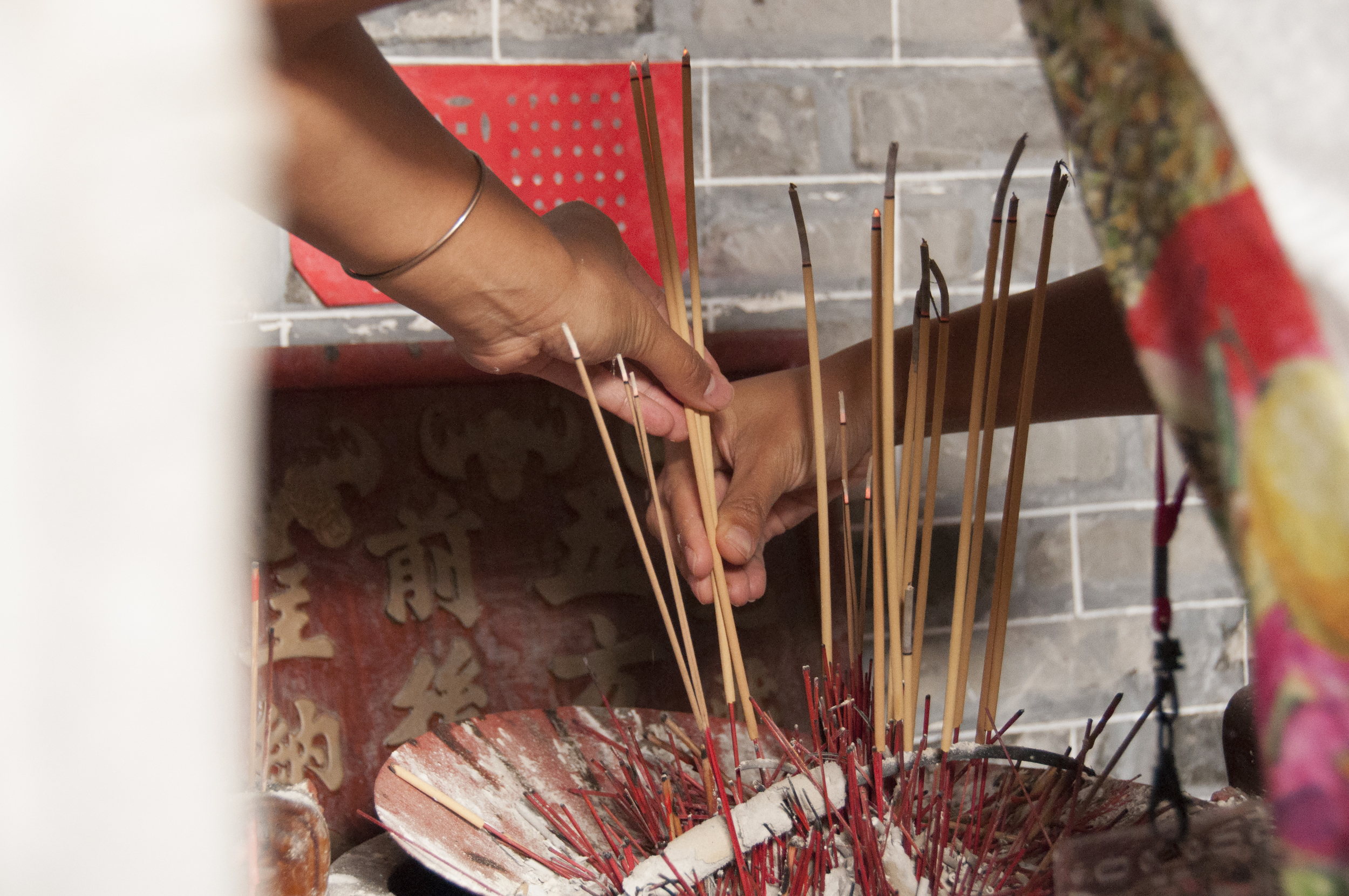 My aunt Ling Yi guides me as I place the incense.