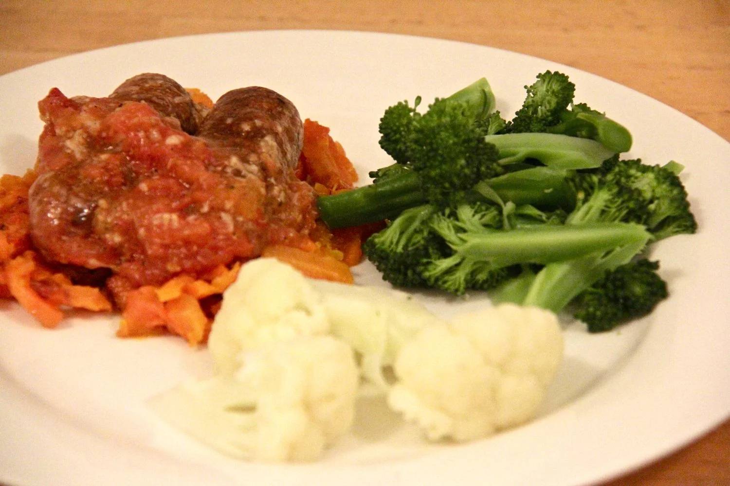 'Roast' Sausages topped with warm tomato and garlic salsa served on smashed roasted carrots