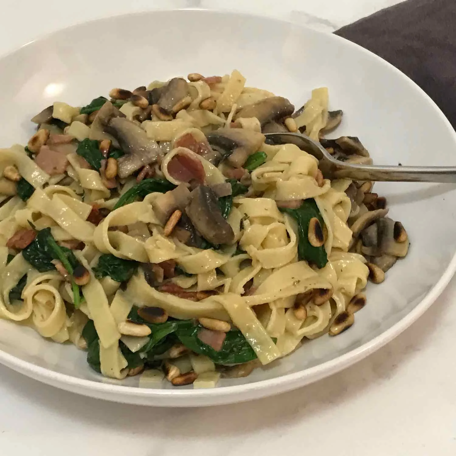 Fresh pasta with pancetta, pinenuts, mushroom & spinach