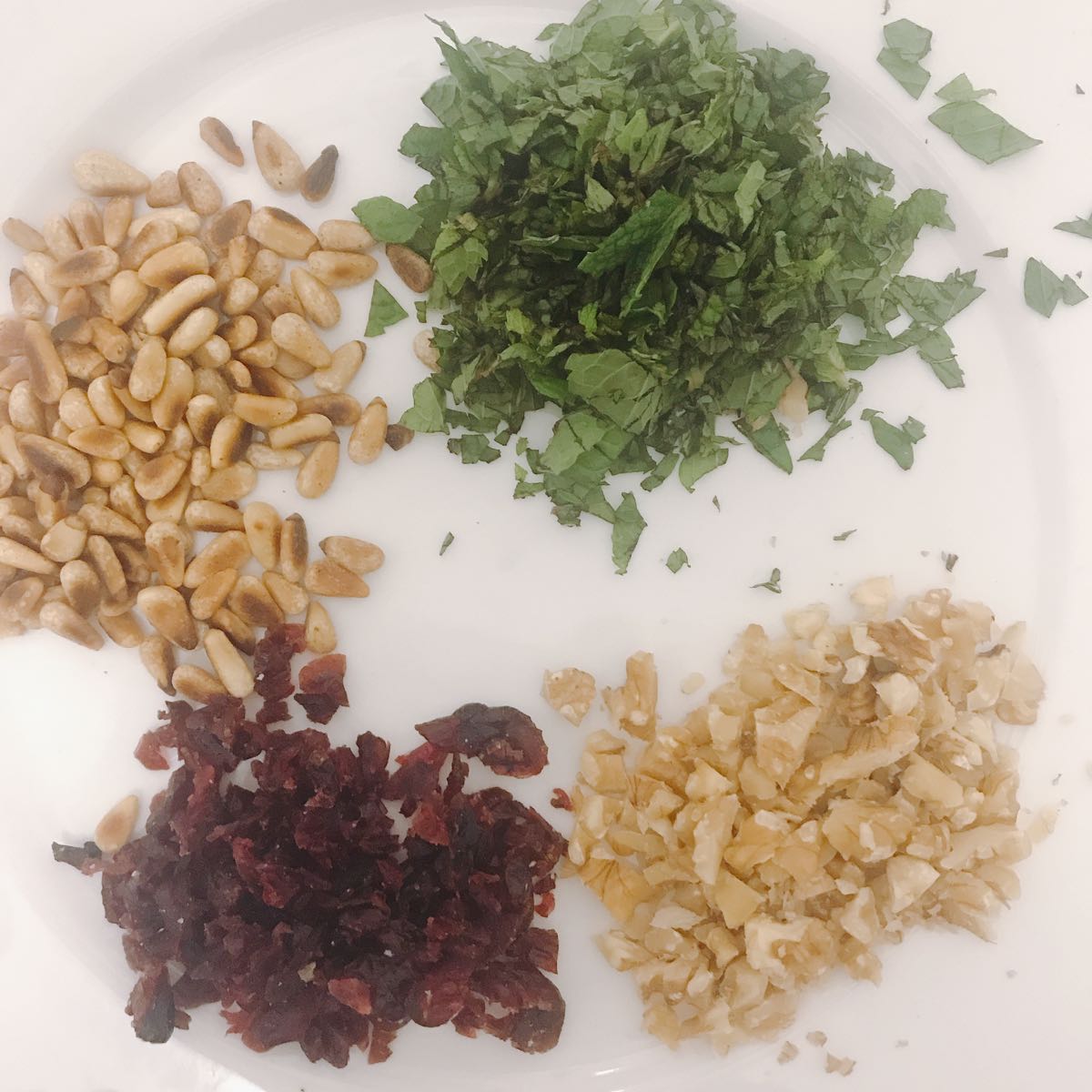 Step 2, chop and prep ingredients for the toppings and salad. Mint, pine nuts, walnuts and cranberries.