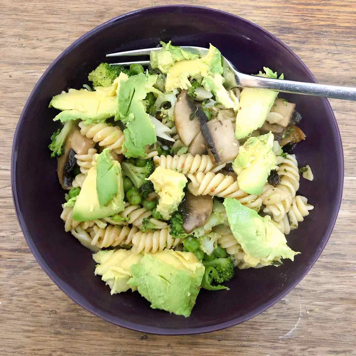 Pasta with creamy mushroom sauce topped with avocado