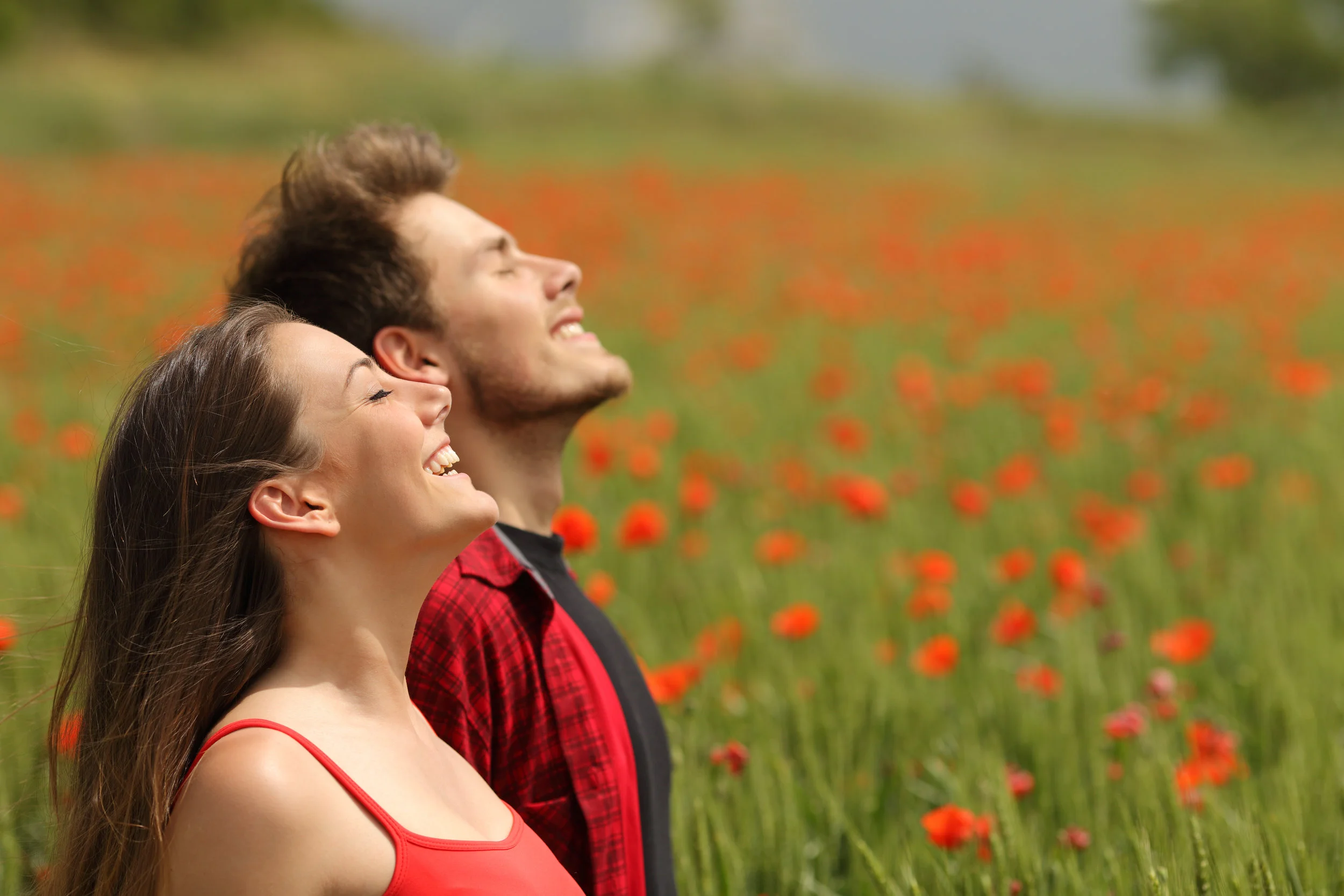 Happy couple breathing fresh air in a red field.jpg