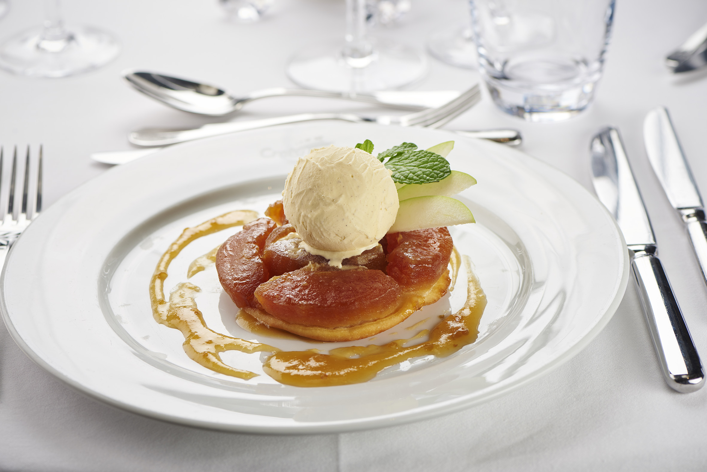 Tarte tatin tiède coulis aux pommes et Calvados glace vanille (Äpplekaka i Calvados med vaniljglass) foto christian creutz