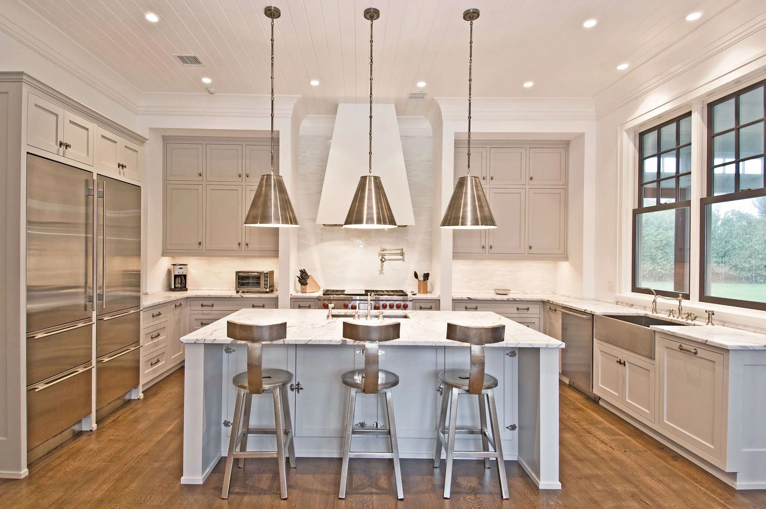 The living room features an expertly crafted coffered ceiling, custom built-ins and an 8-foot Marvin Inswing Patio Door with Transoms.