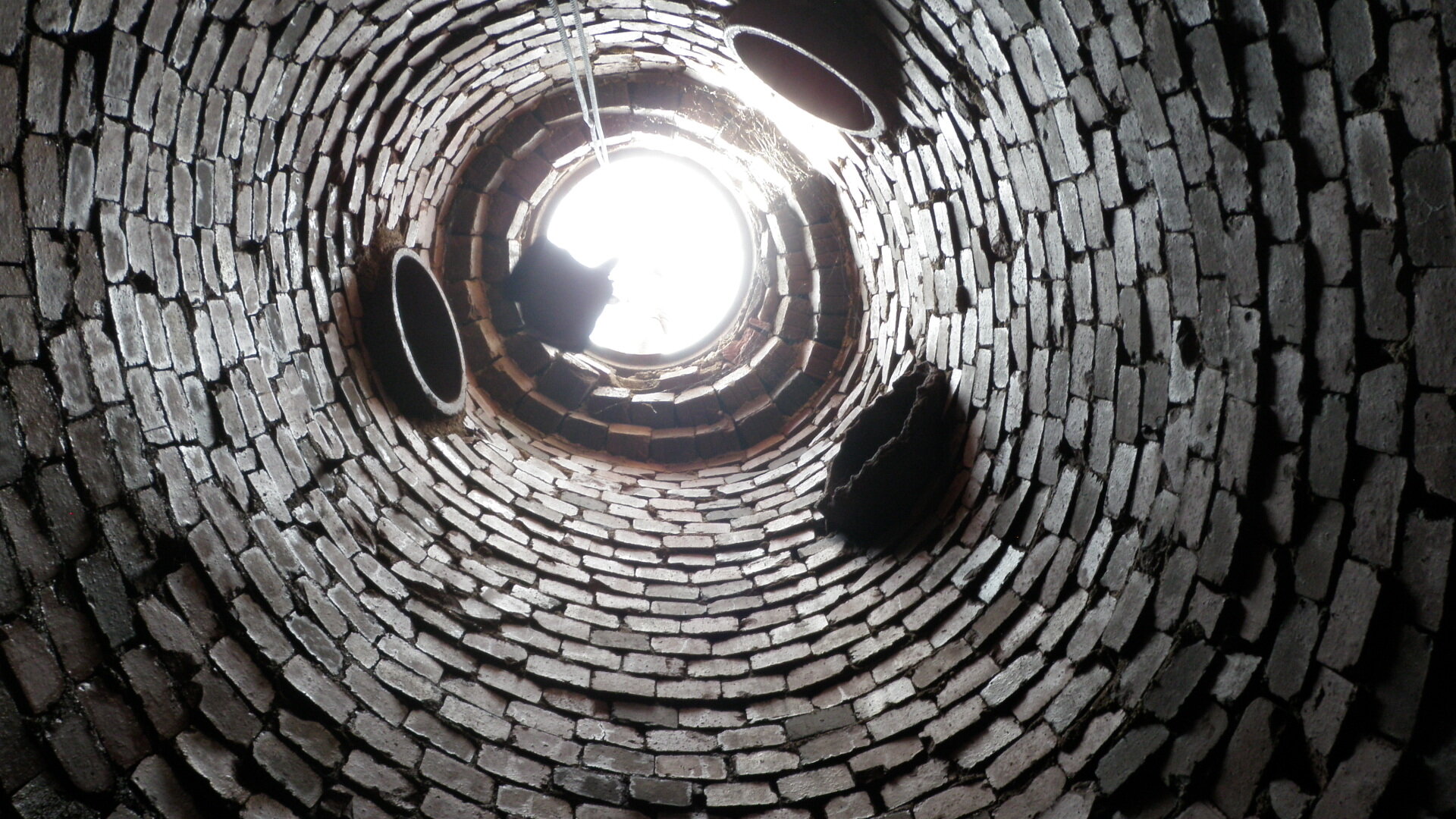  Another view looking up from the bottom of a manhole, with multiple incoming lateral pipes. 