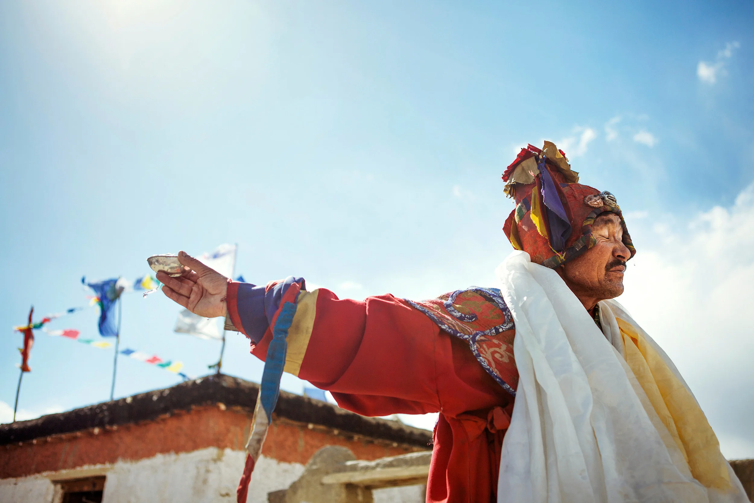 Lama-with-a-cup-of-alcohol-during-a-trance,-full-moon-ceremony-in-Dhankar,-Spiti-Valley,-India.jpg