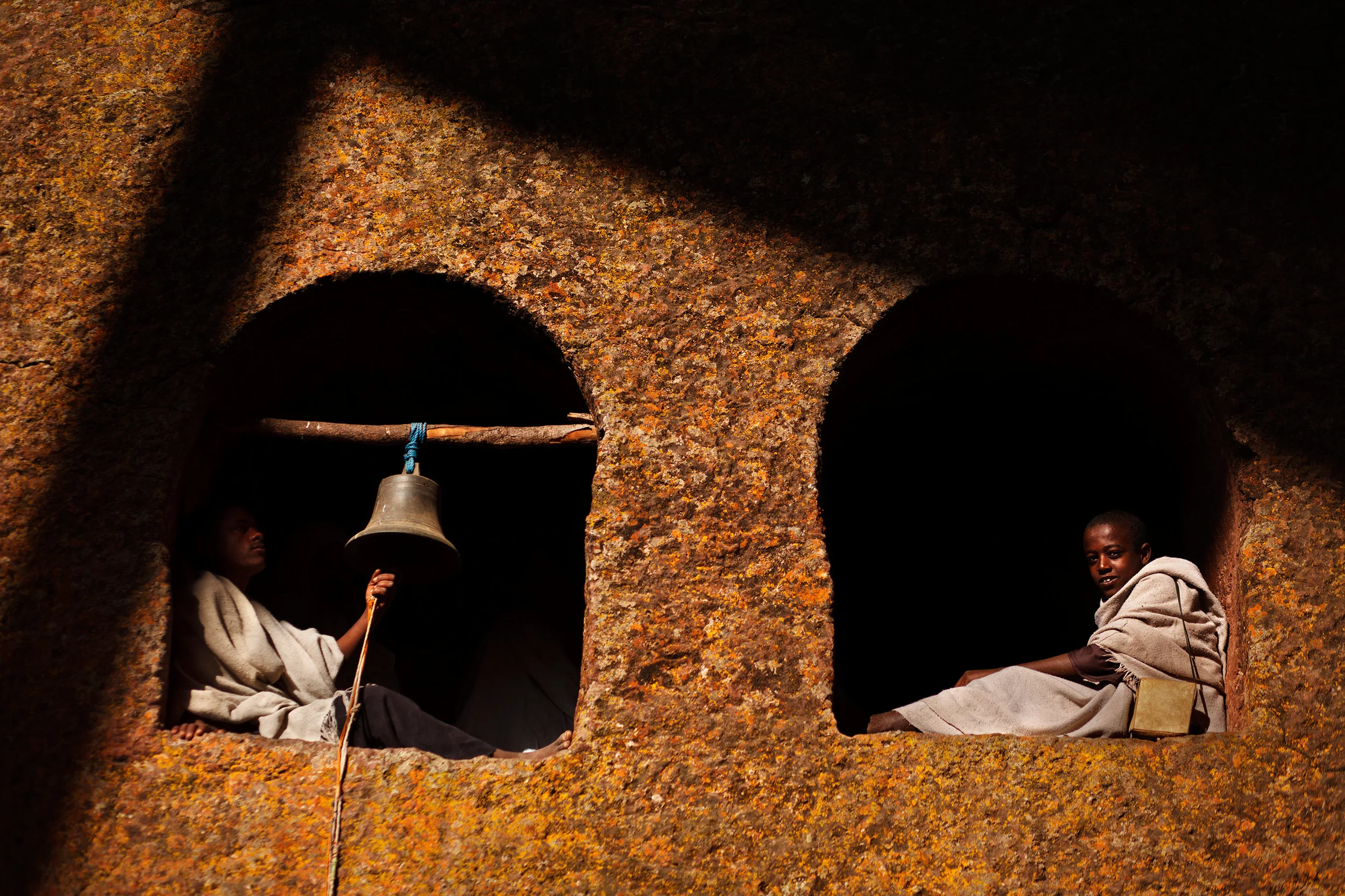 Young boys sit in the bell tower of Beta Maryam rock church.