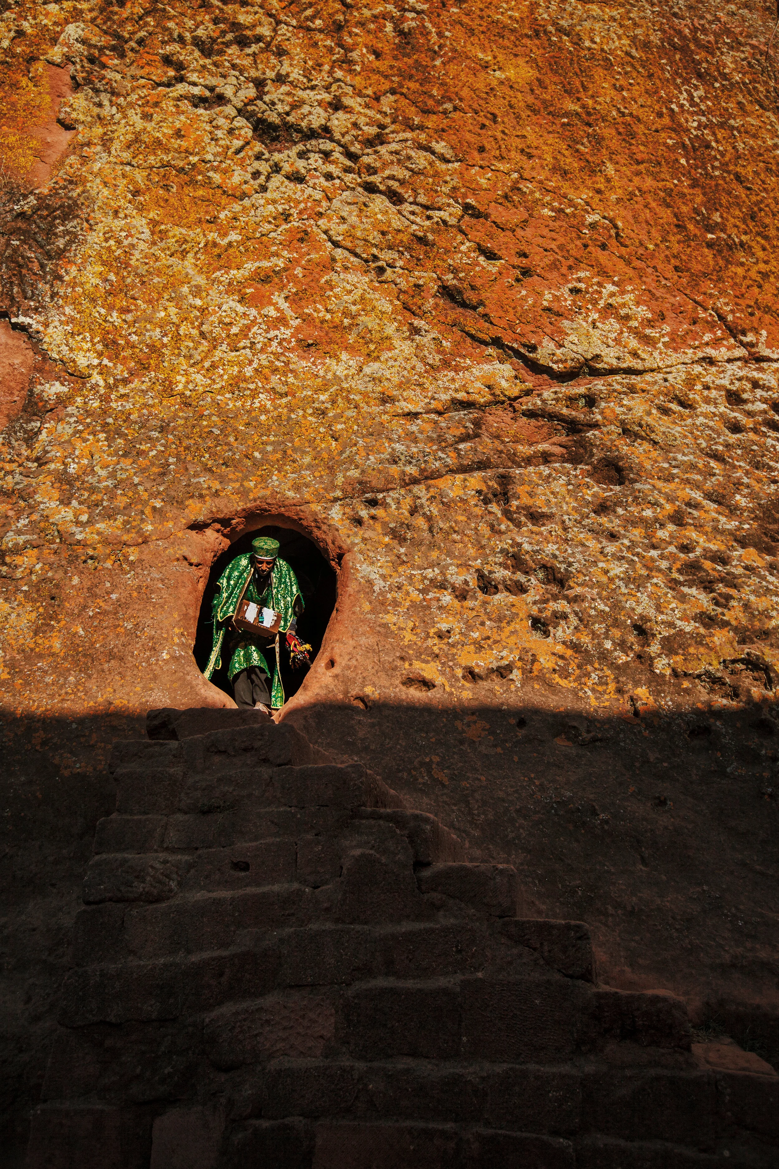 Deacon-exiting-a-rock-church-in-Lalibela,-Ethiopia.jpg