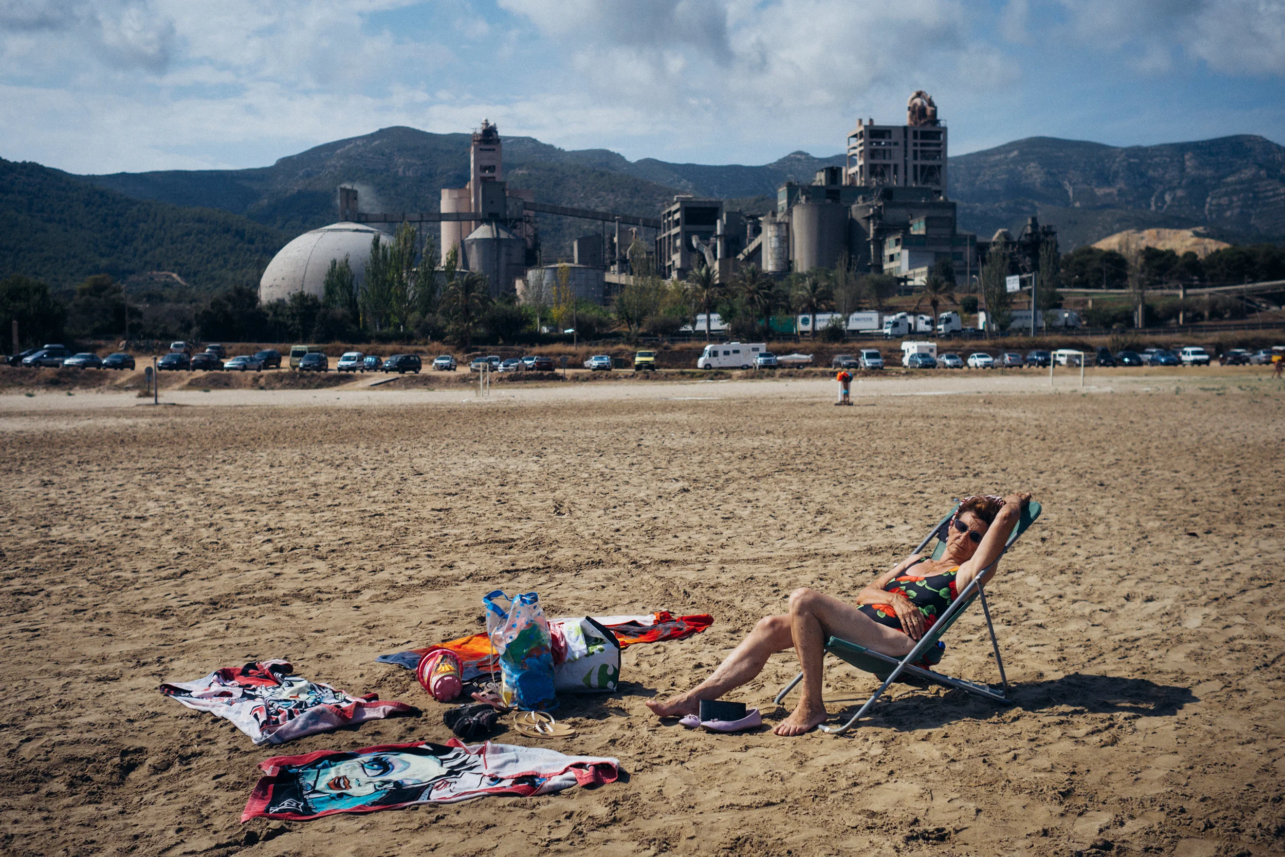 Woman sunbathing in front of a factory