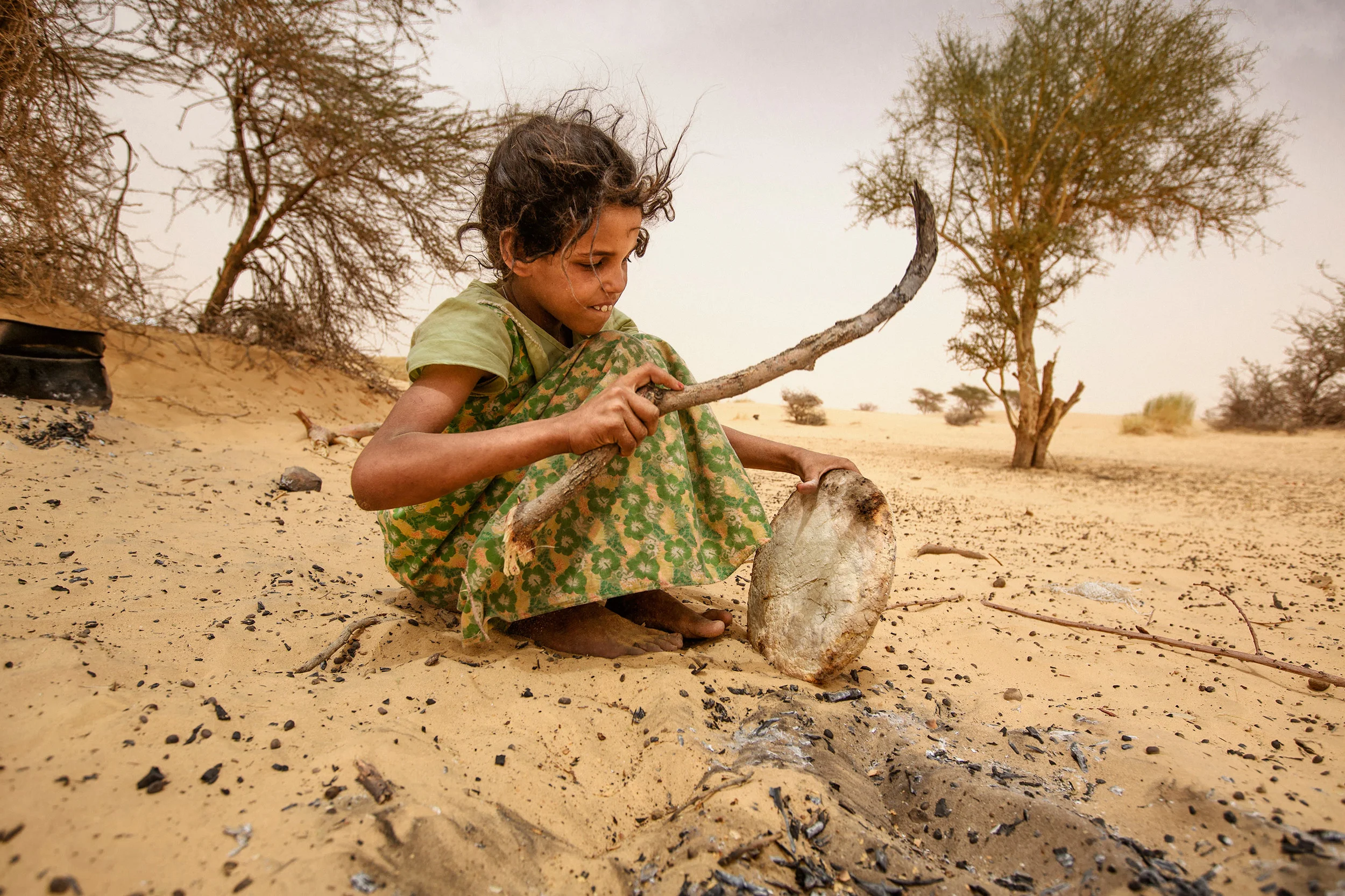 Taking-bread-out-of-sand-after-baking-it-there---Mauritania,-Adrar.jpg