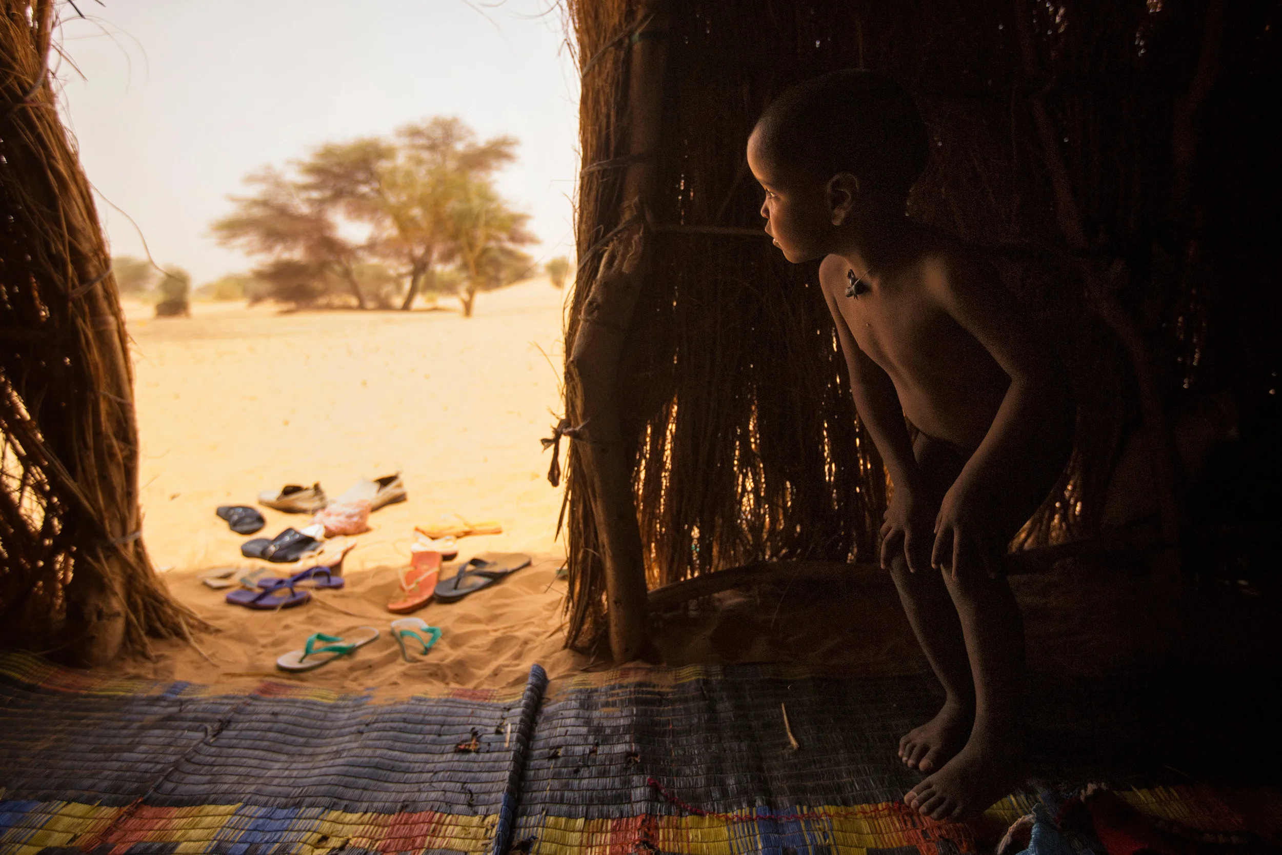 Mauritania,-Adrar---Nomad-child-looks-out-from-his-family's-hut.jpg