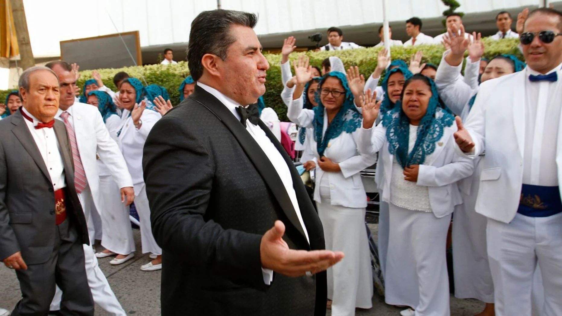 Aug. 14, 2018 photo, Joaquín García, 50, greets members of his church "La Luz del Mundo" in Guadalajara, Mexico