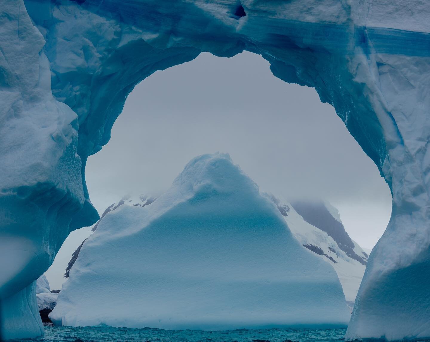 Window to another world. 

I find ice arches so mesmerizing.  Like a rock arch, but evolving so much faster. Sculpted by the elements, and passing through phases of melting, shifting, rolling, and crackling. I was lucky enough to sit by this arch for