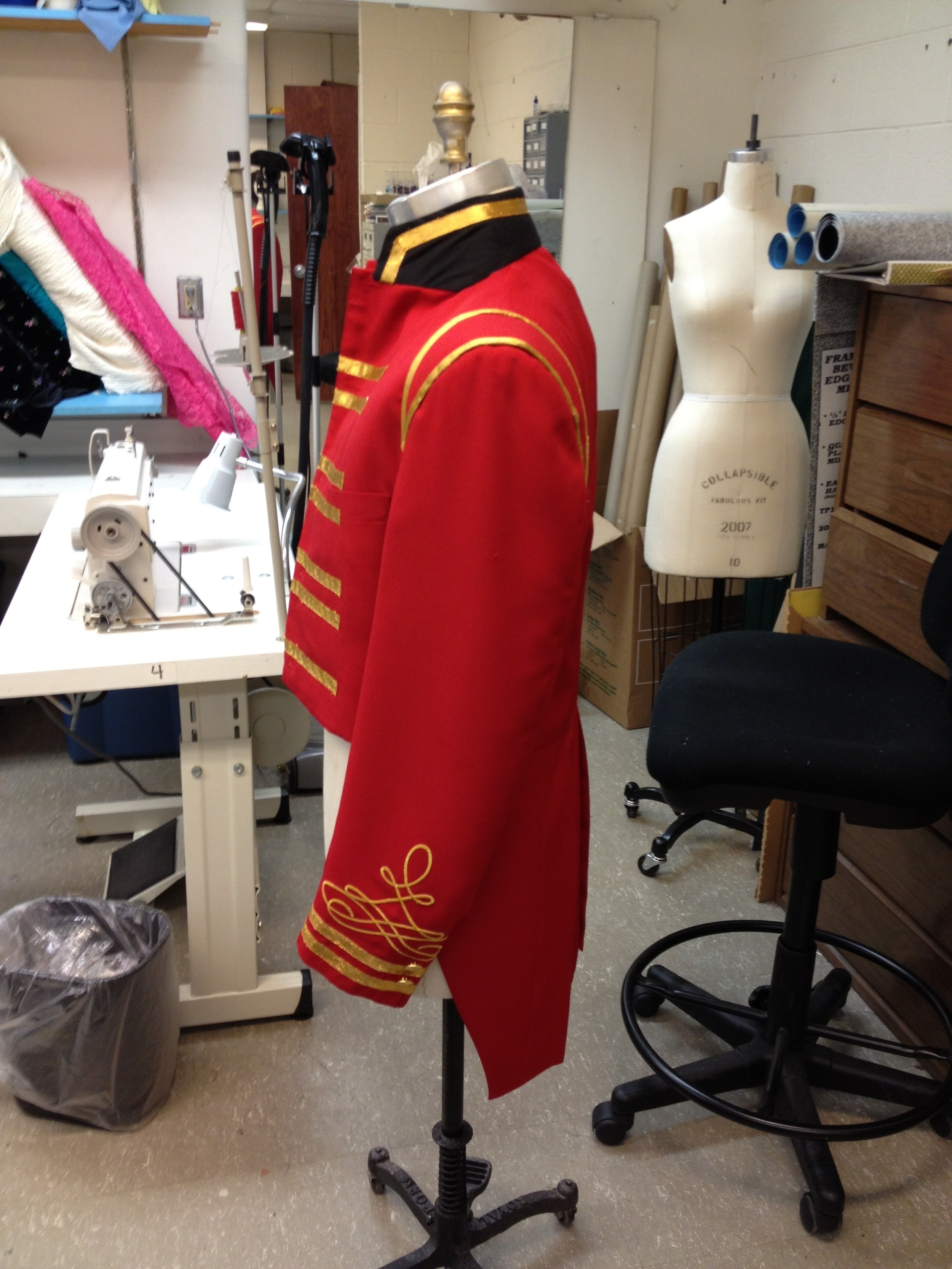 Underside of coat collar turned up, covered, and trimmed in gold.