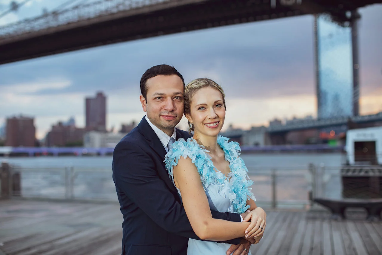 A couple poses in front of the Brooklyn Bridge at Sunrise | Brooklyn Bridge Anniversary Session | Brooklyn Bridge Wedding Photos | Early morning Brooklyn Bridge Engagement Photos