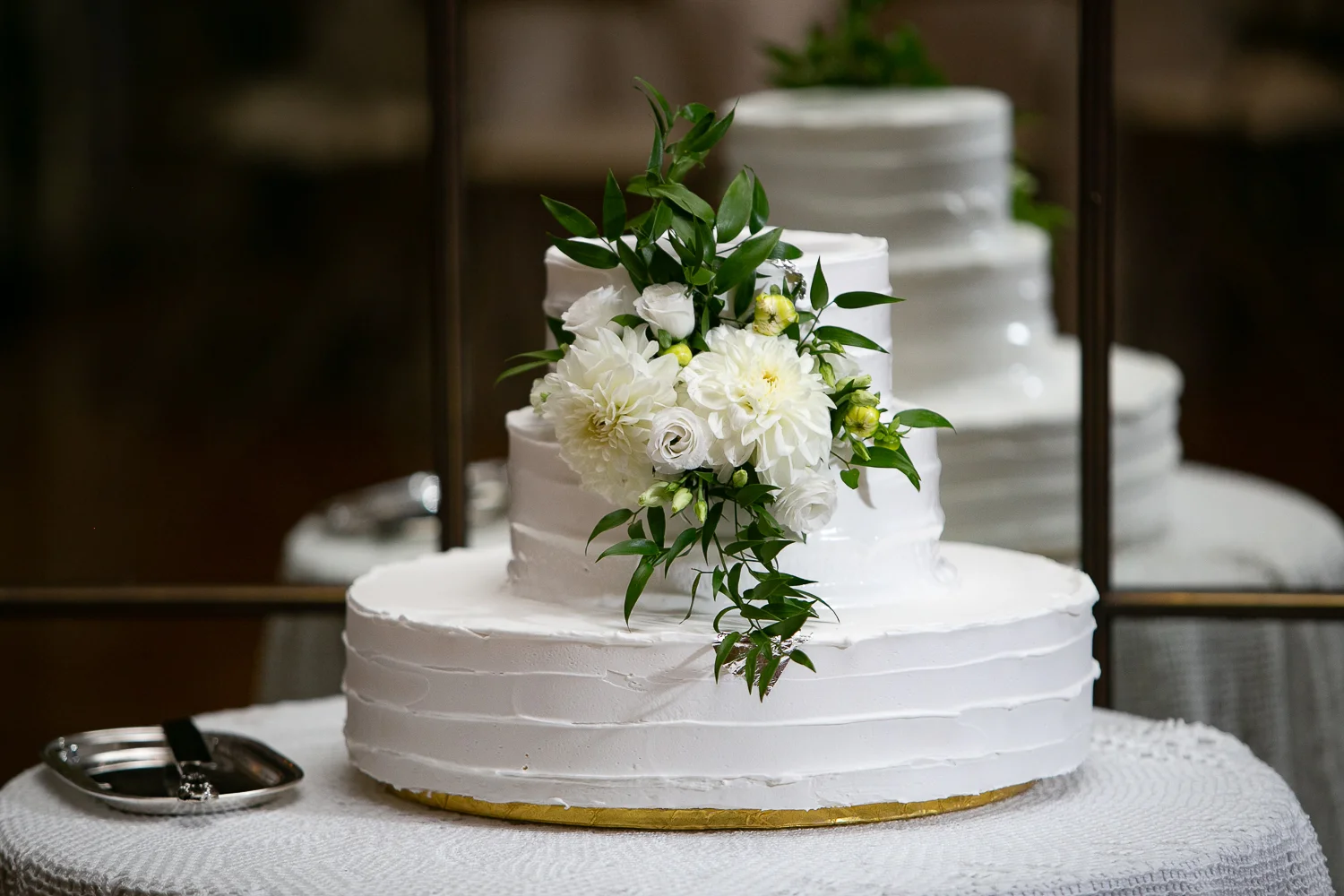 Wedding cake with white flowers and greenery.