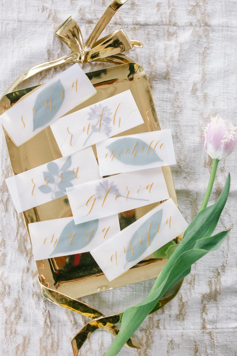 Gold embossed seating cards on a gold tray - Nancy Moy Calligraphy - NoMad Hotel Wedding in New York City