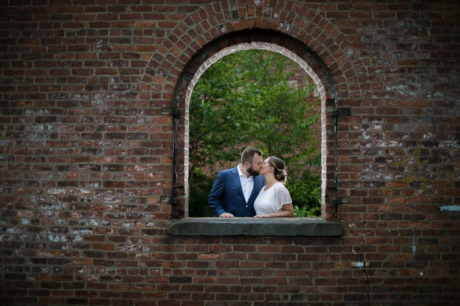 Bride and groom kissing against a brick wall. | Intimate Wedding at the Malthouse in Manhattan, New York City.