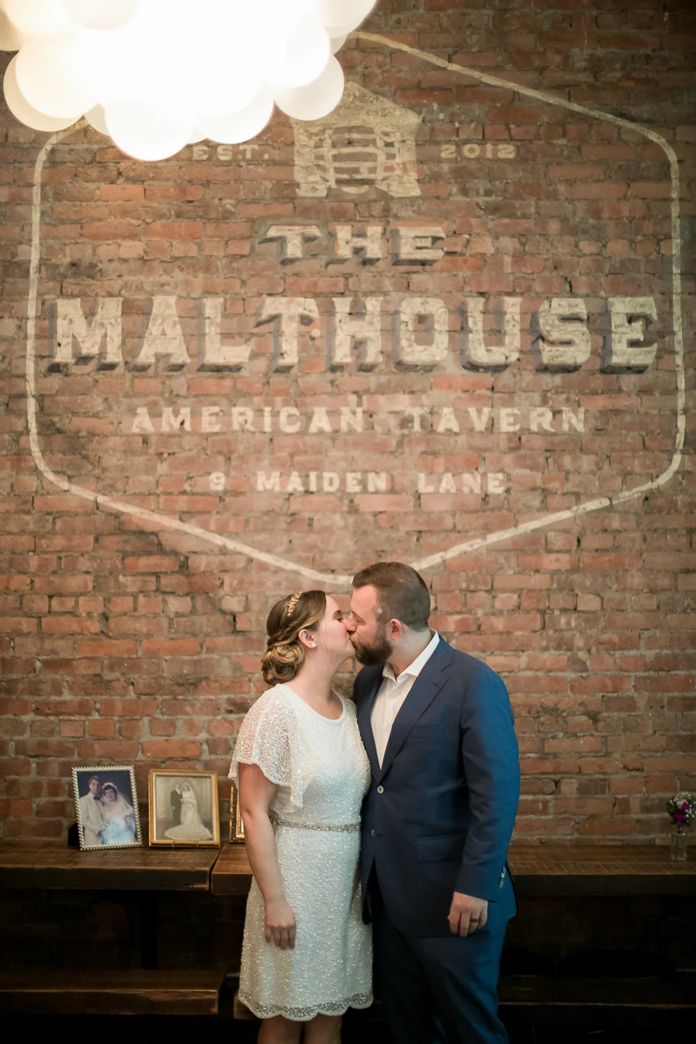 Bride and groom kissing in front of a brick wall at an Intimate Wedding at the Malthouse in Manhattan, New York City.