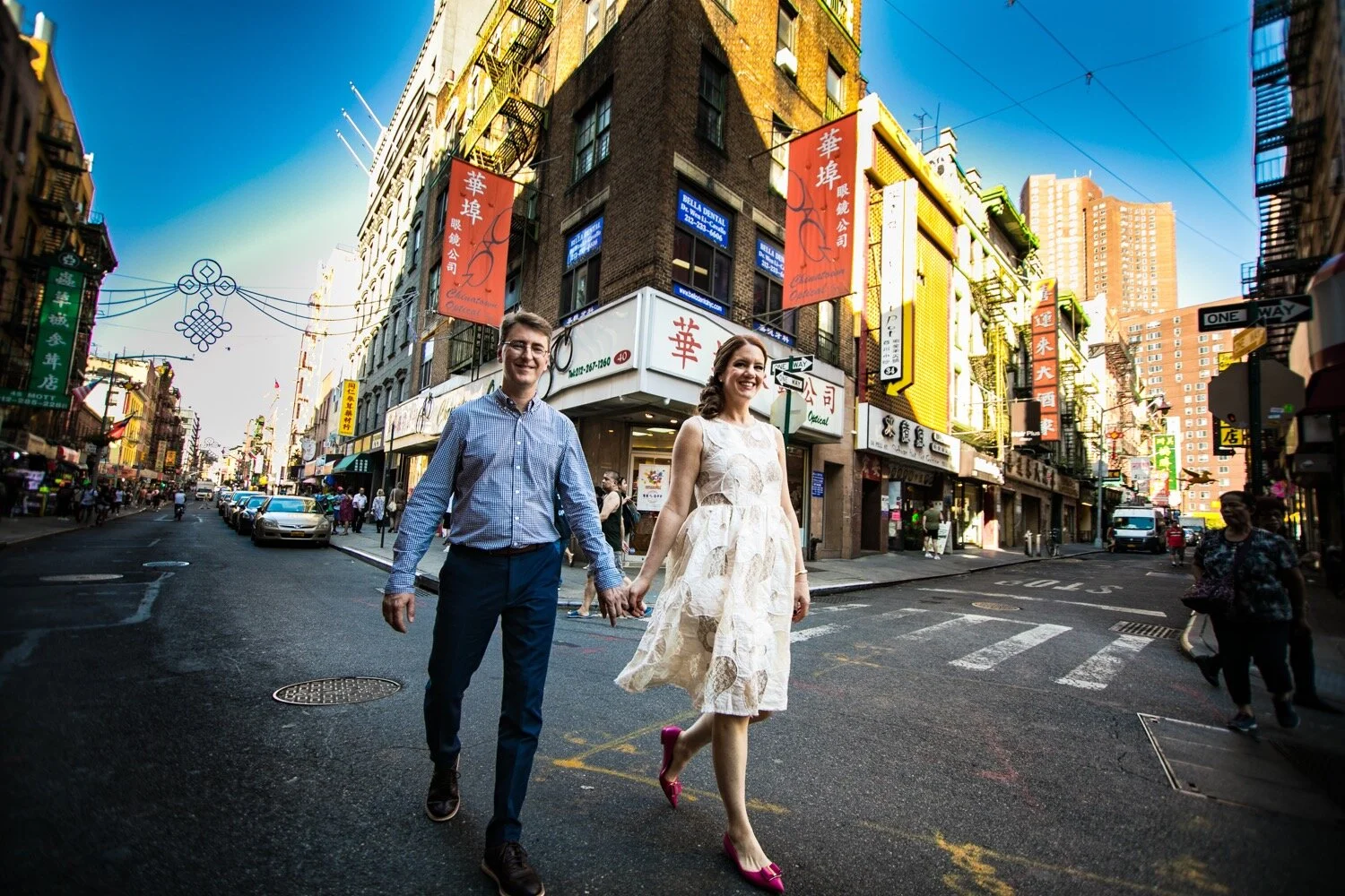 A quirky wedding photo using a wide angle lens, showing the bride and groom in Chinatown, NYC.