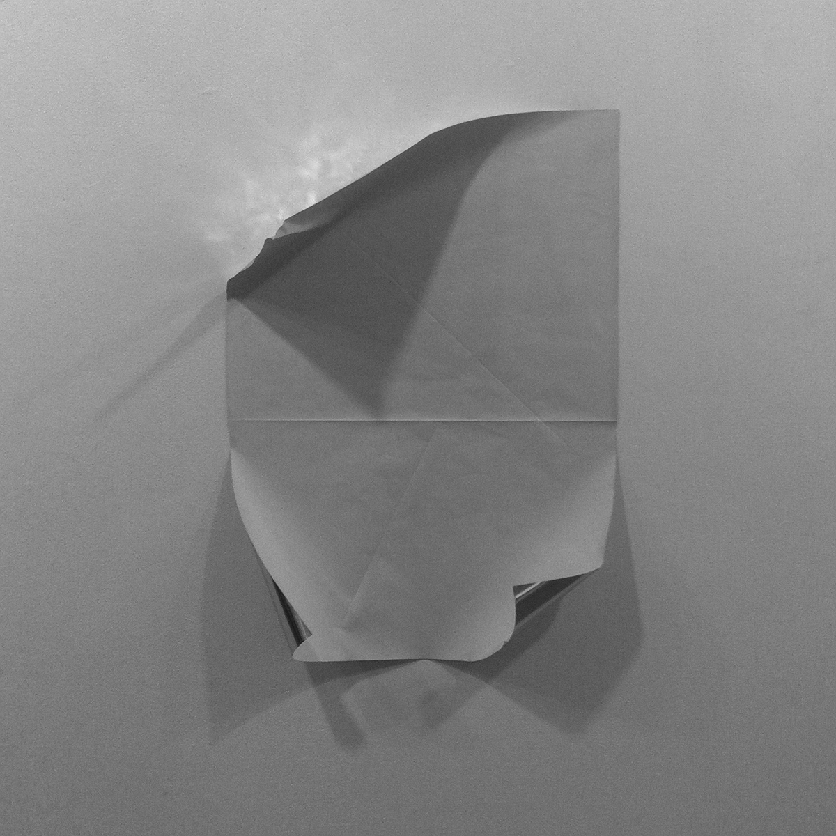  Untitled (from within)  2014, Temporary site specific installation, reflective paper folded and adhered to a wall with an external spotlight. 30 x 30 inches  
