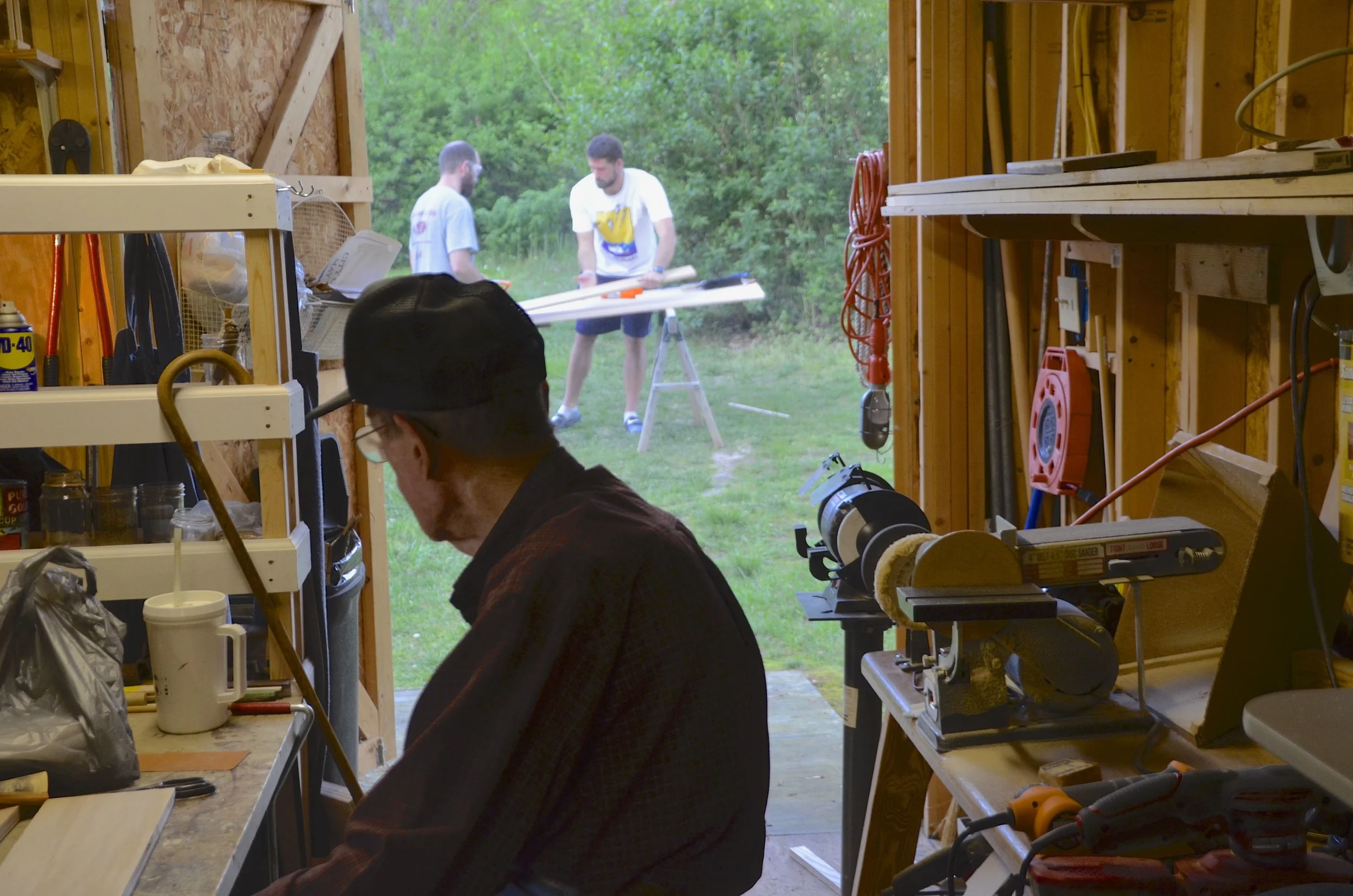 Granddad watching Corbin and I cut some wood from inside his shop.