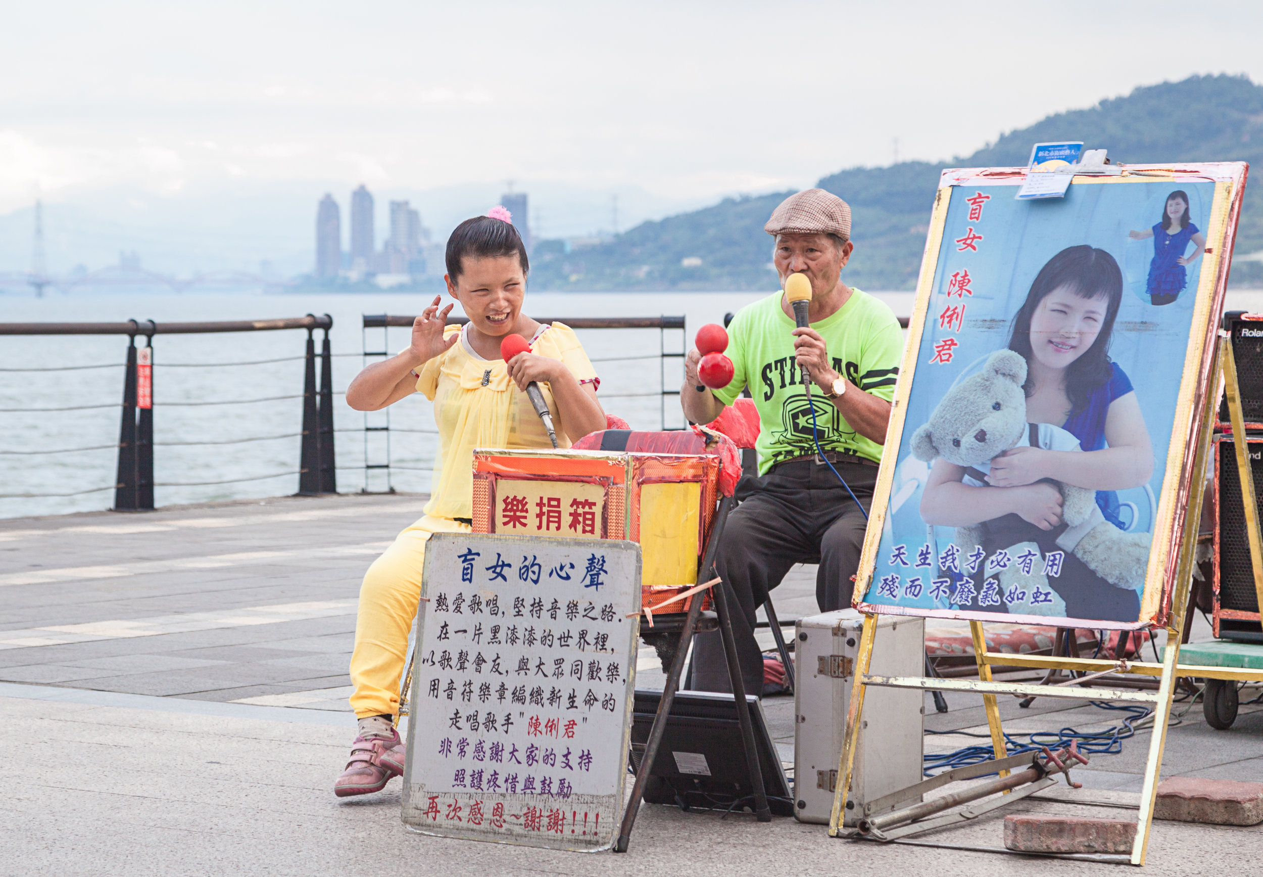 A singer with no eyes performs upbeat Chinese classics to passersby in Tamsui