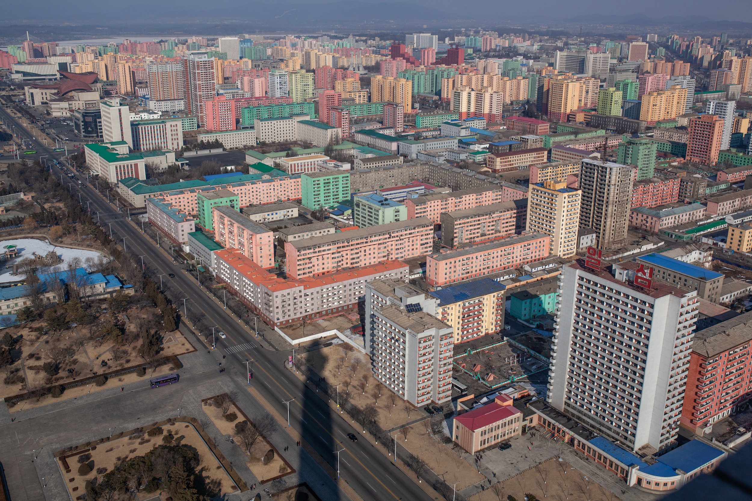 A view over a residential district of Pyongyang from the top of the Juche Tower, the shadow of which can be seen at the bottom of the image.