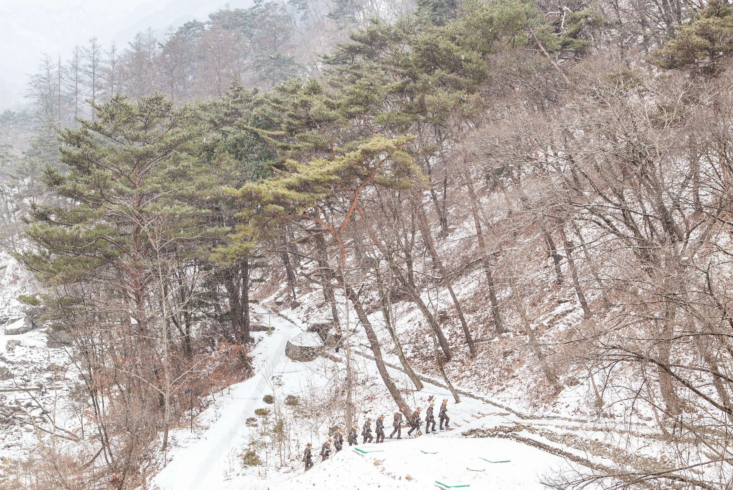 Soldiers trek along a snowy path in Myohyangsan National Park.
