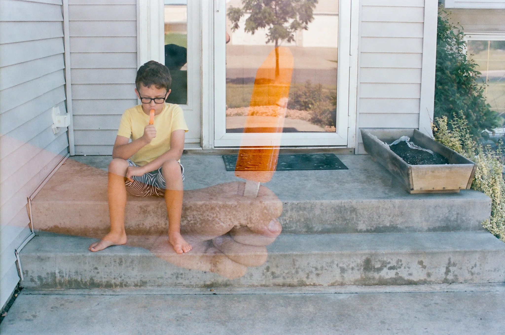 Boy and popsicle front step double exposure